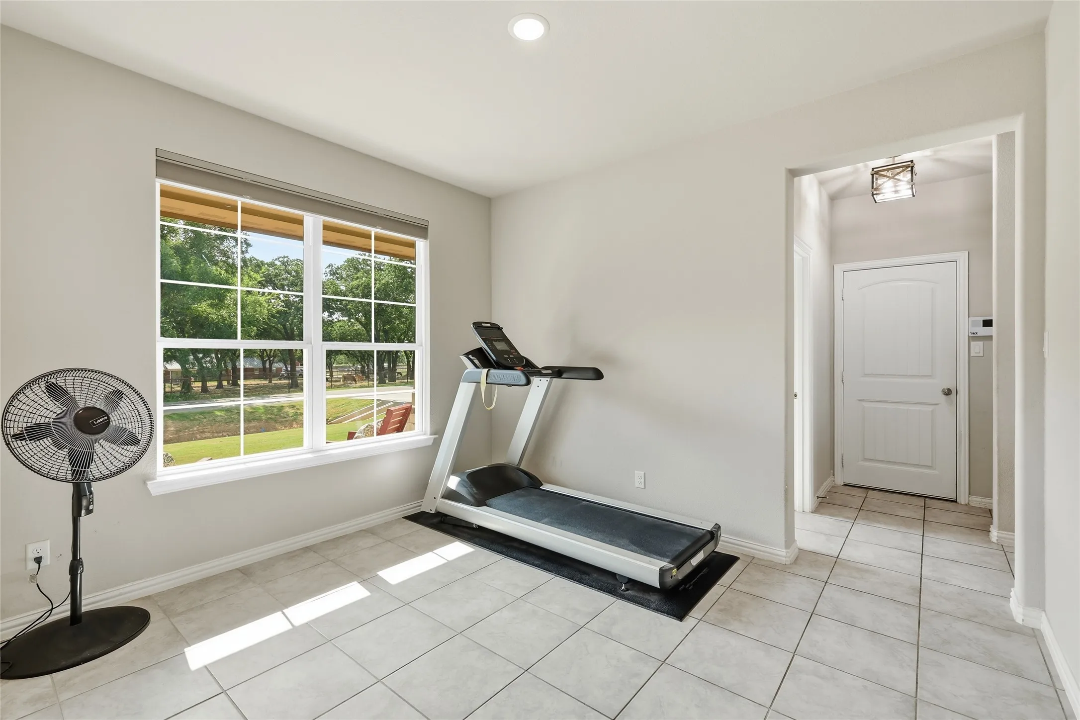 Recessed lighting, large window with blinds, tile flooring, and a paneled interior door