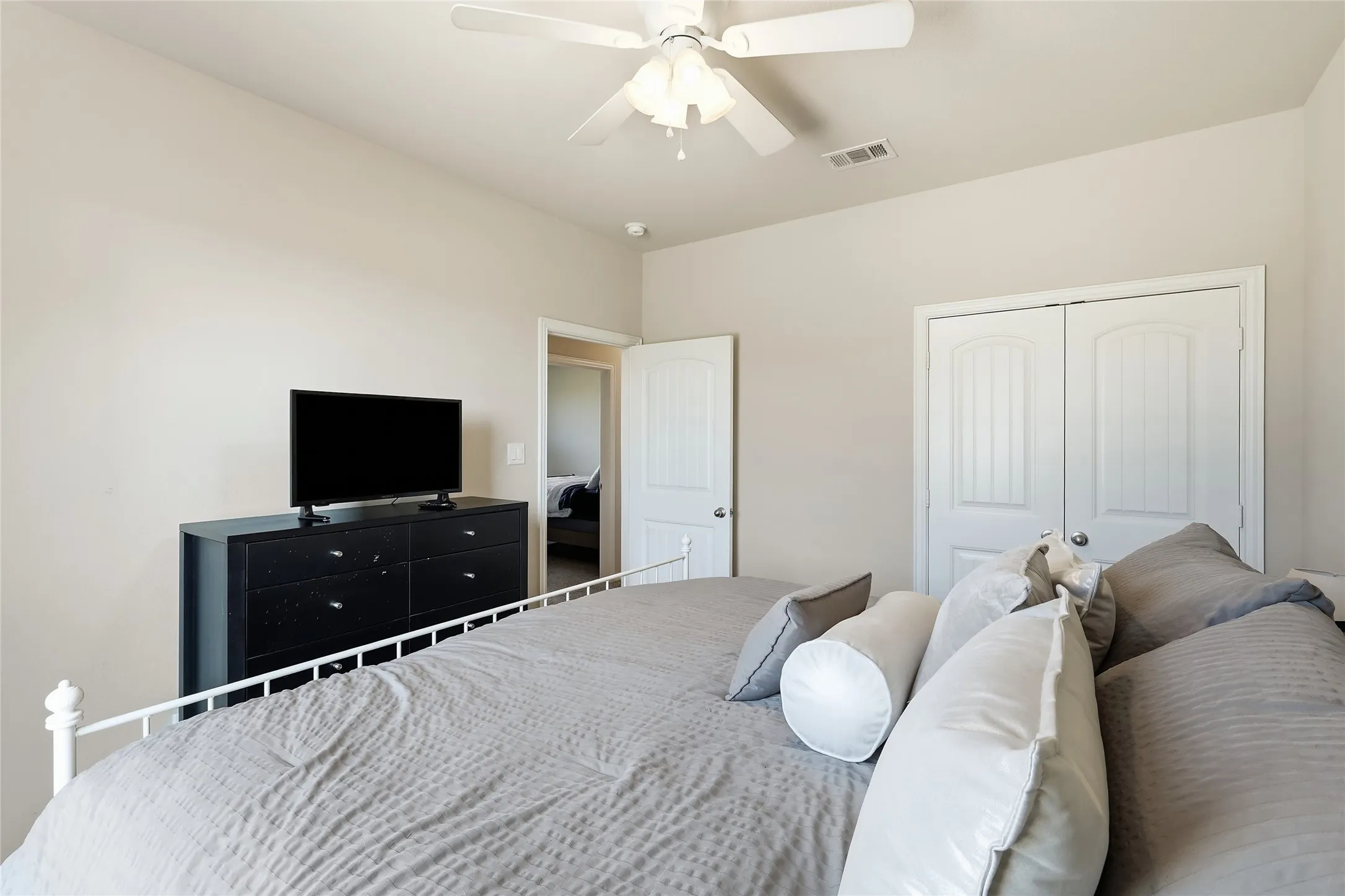 White paneled doors, ceiling fan with integrated lighting, and neutral wall tones