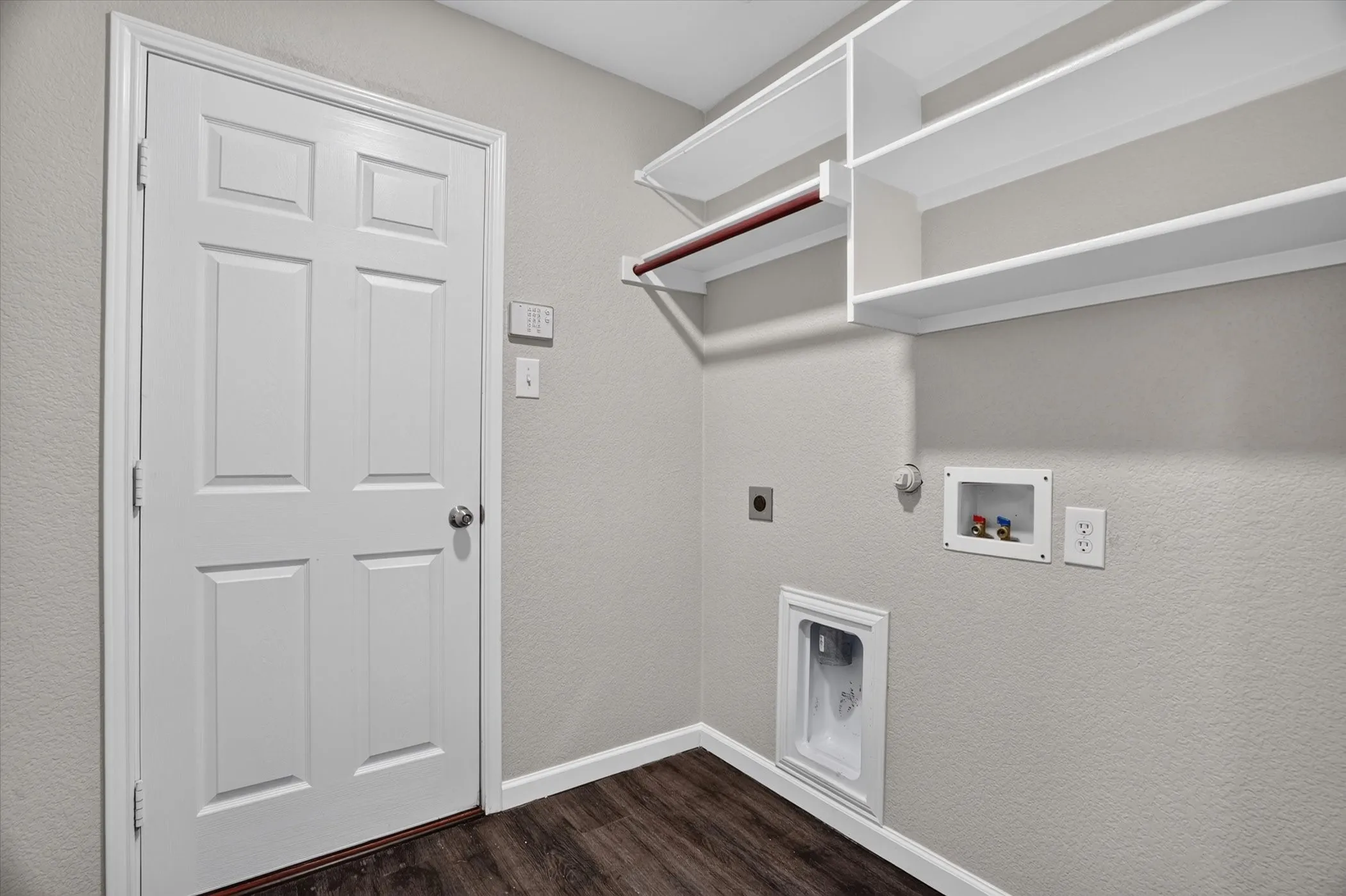 Spacious walk-in closet featuring built-in shelving and hanging rods, wood-finish flooring, and abundant natural light from recessed ceiling fixtures