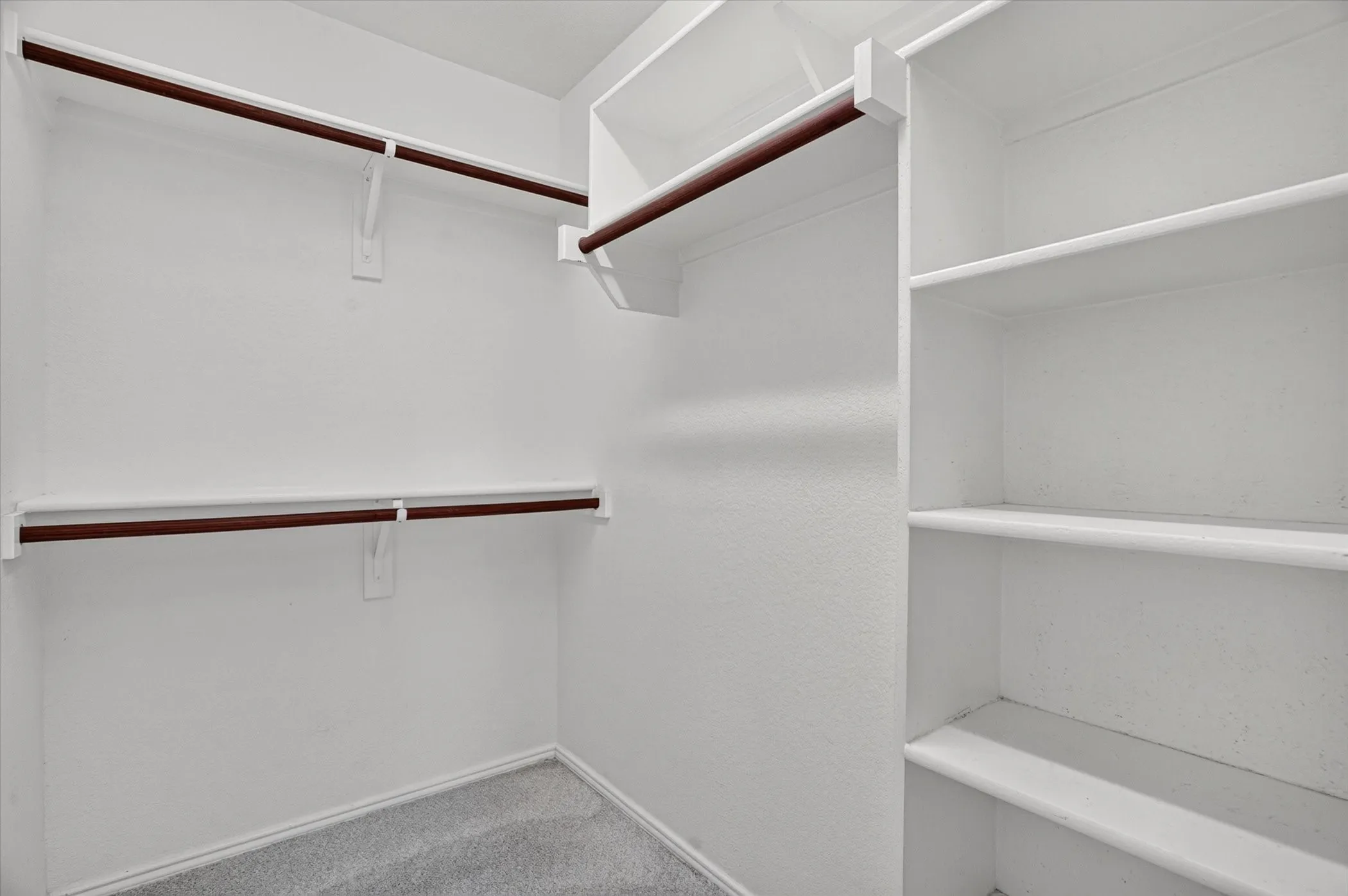 Walk-in closet with integrated shelving and multiple hanging rods
