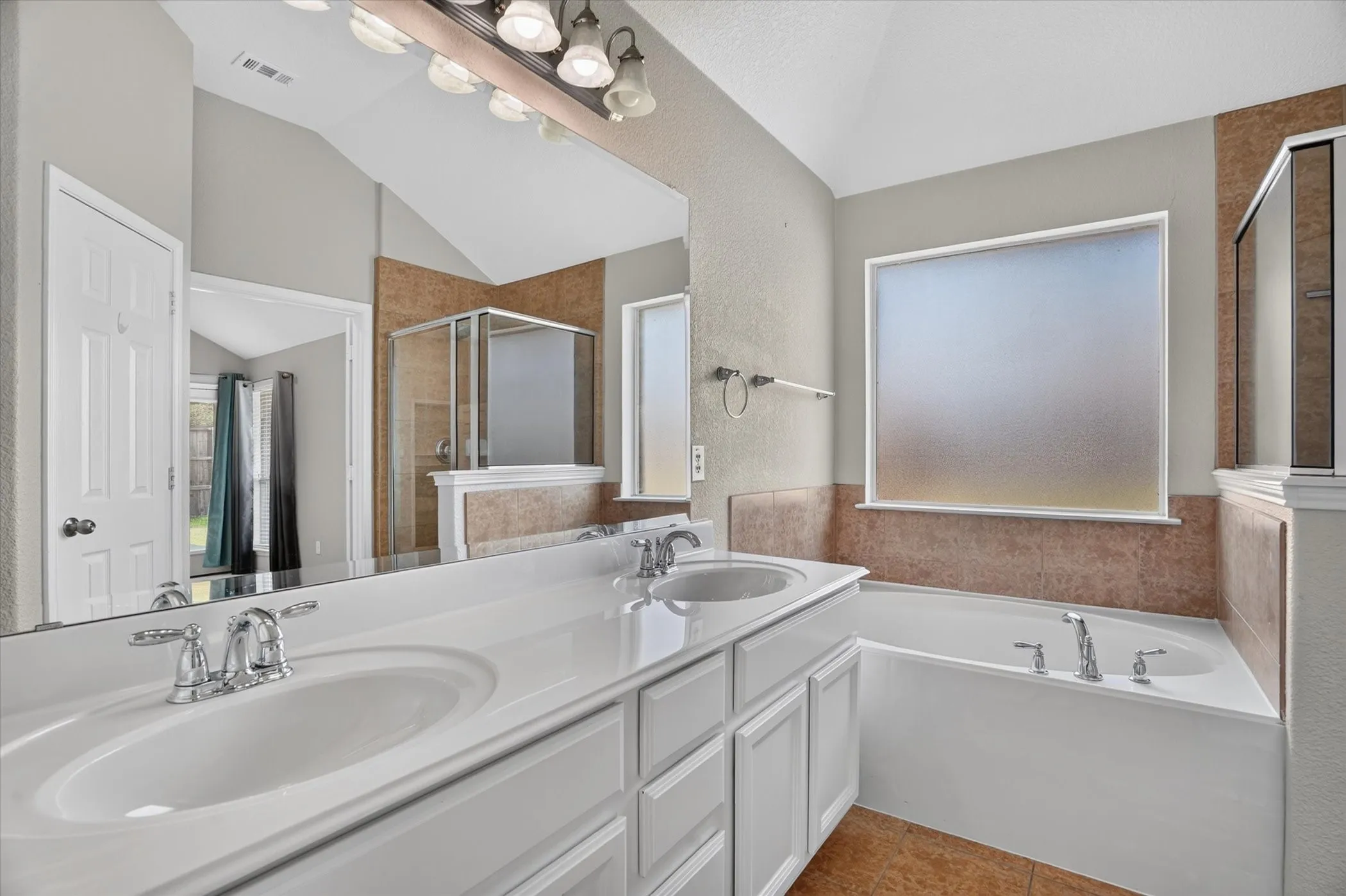 Dual vanity with integrated sinks, chrome fixtures, and white cabinetry