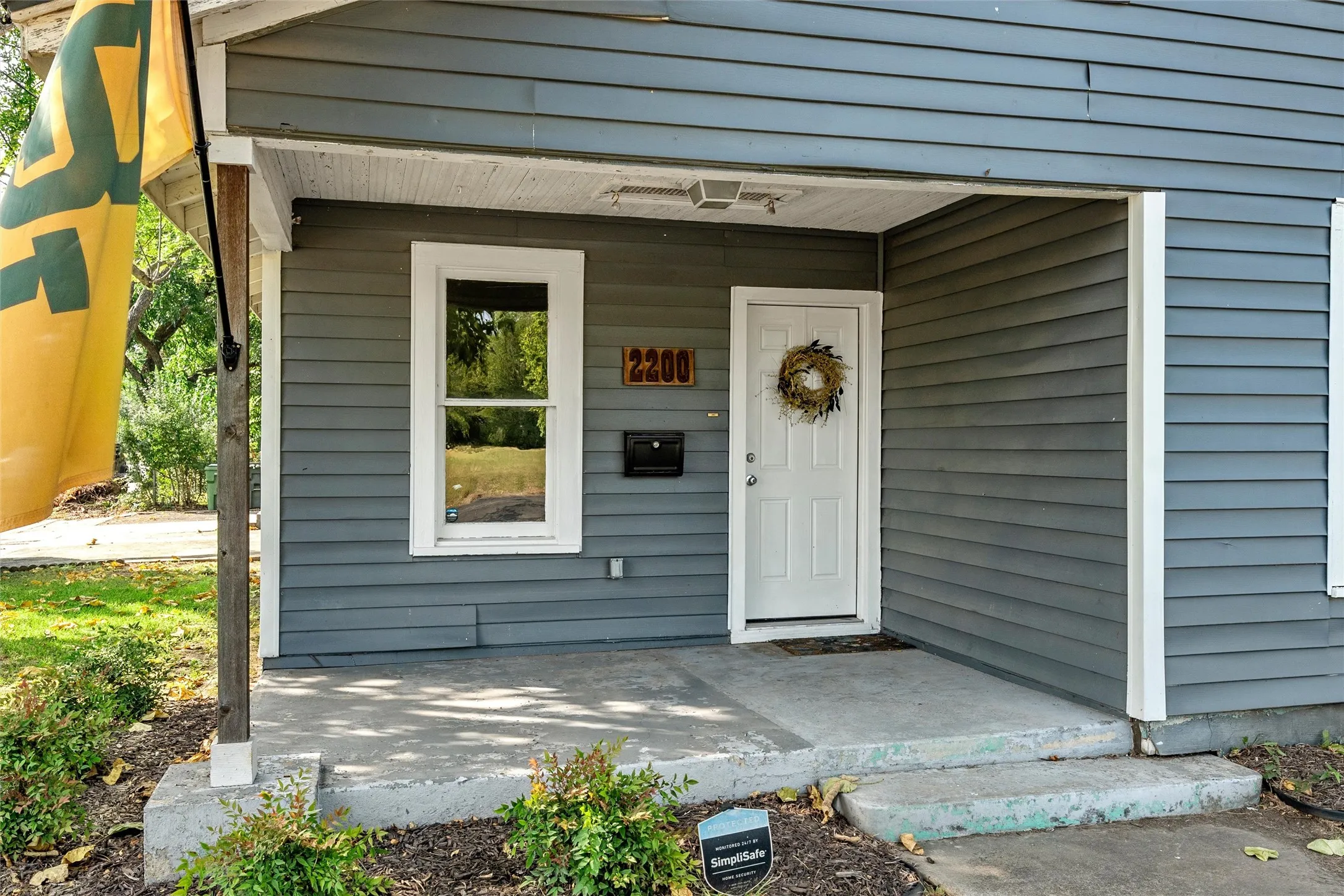 Covered front porch with concrete flooring and steps