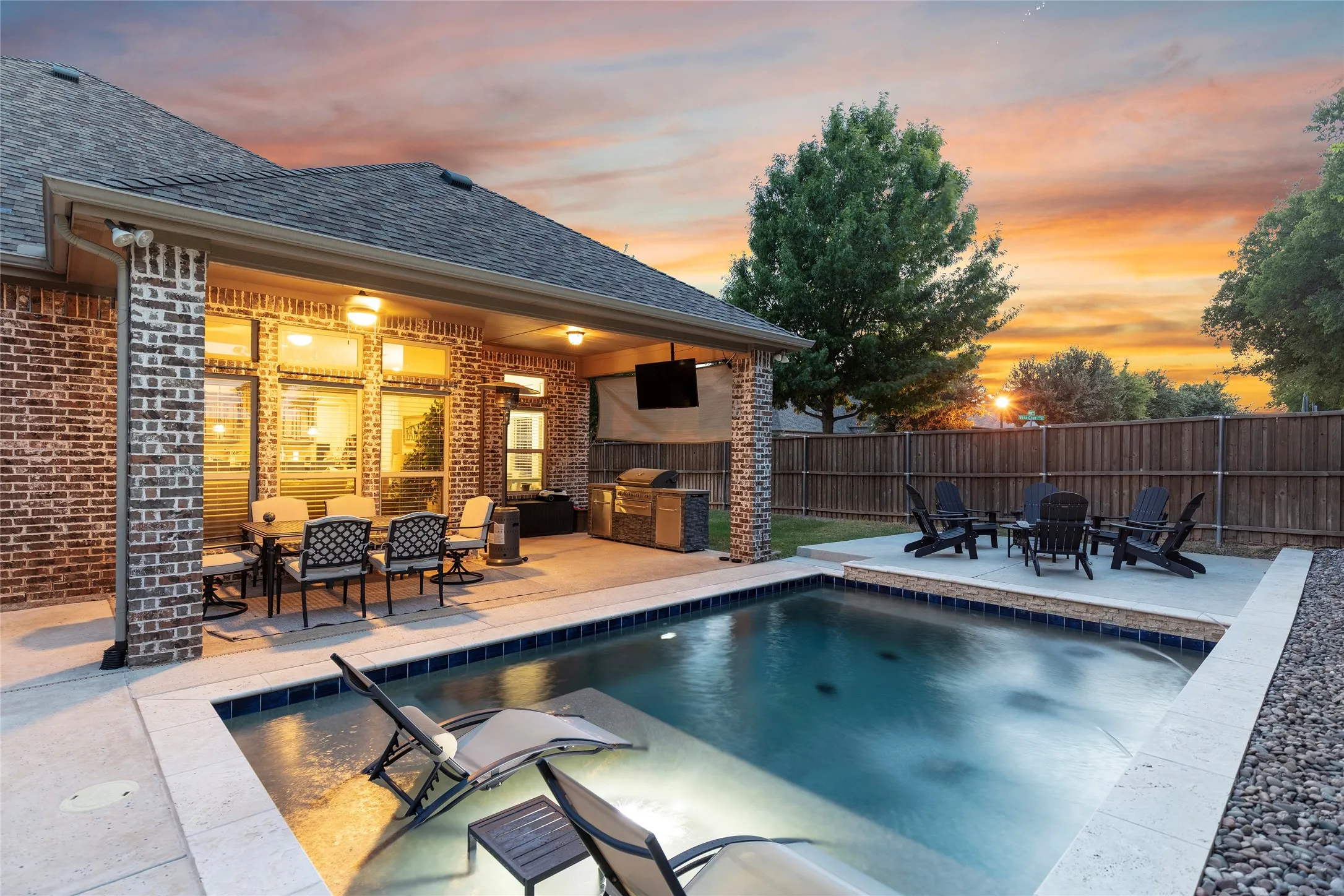 Twilight view of pool and yard