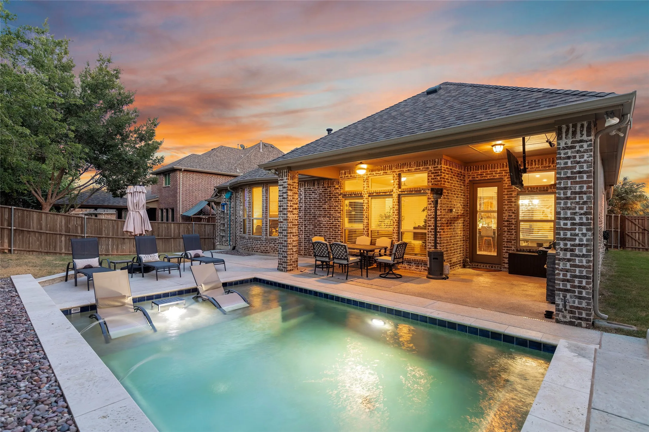 Twilight photo of pool and yard