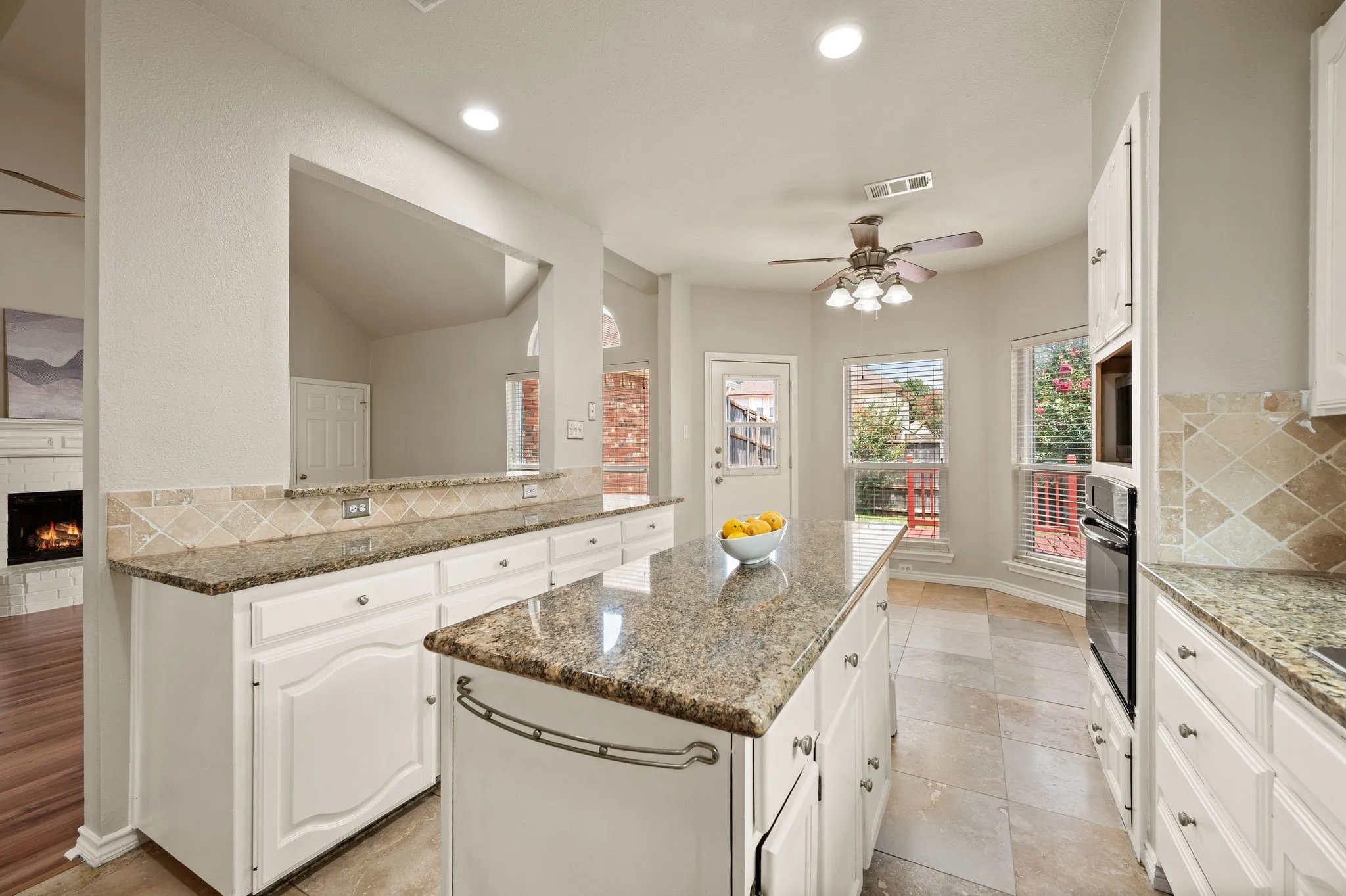 Kitchen featuring white cabinetry, granite countertops, tile flooring, a built-in oven, and a ceiling fan
