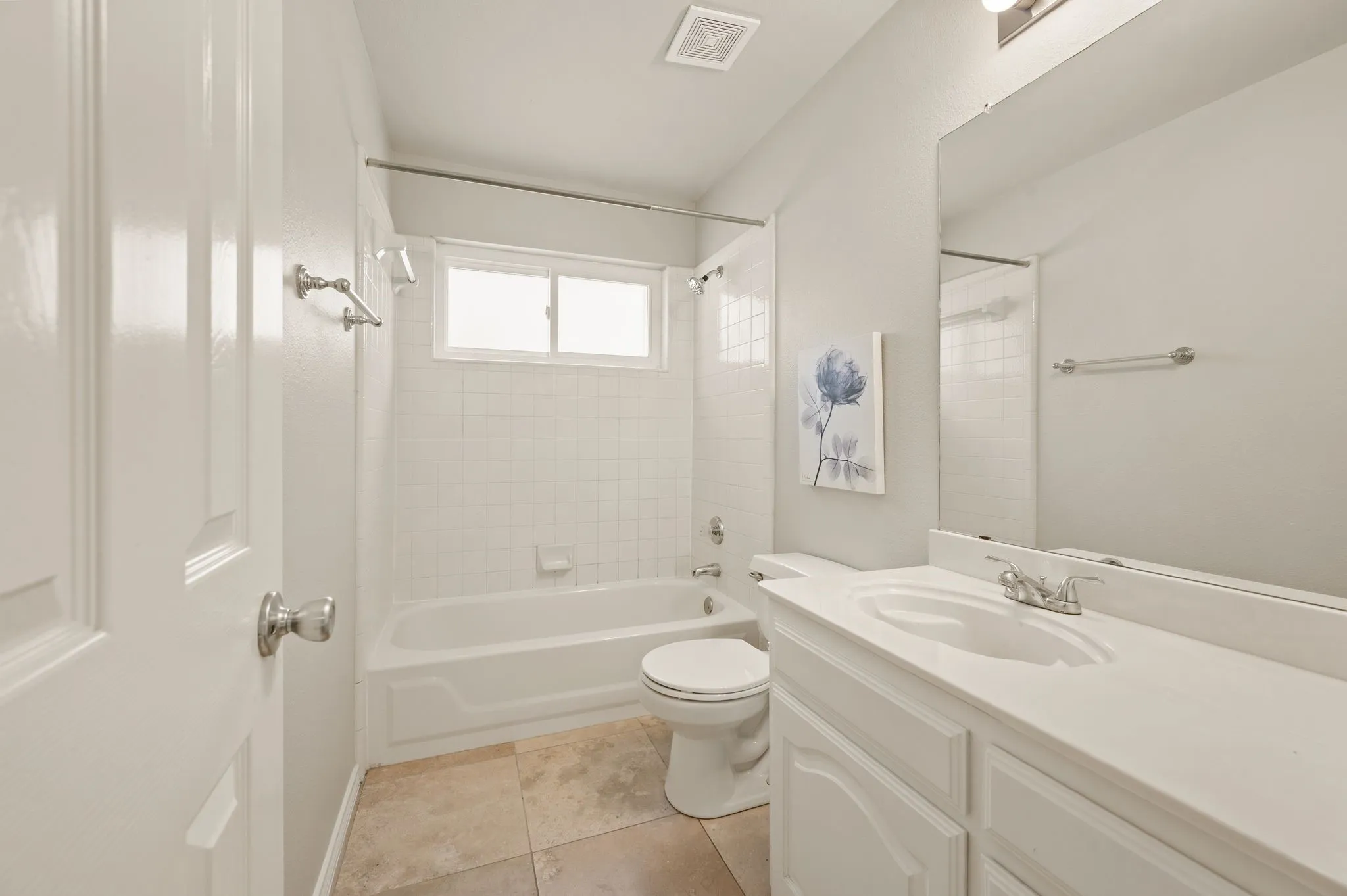 Bright and functional bathroom featuring a white vanity with dual sink configuration, brushed nickel fixtures, and ample storage