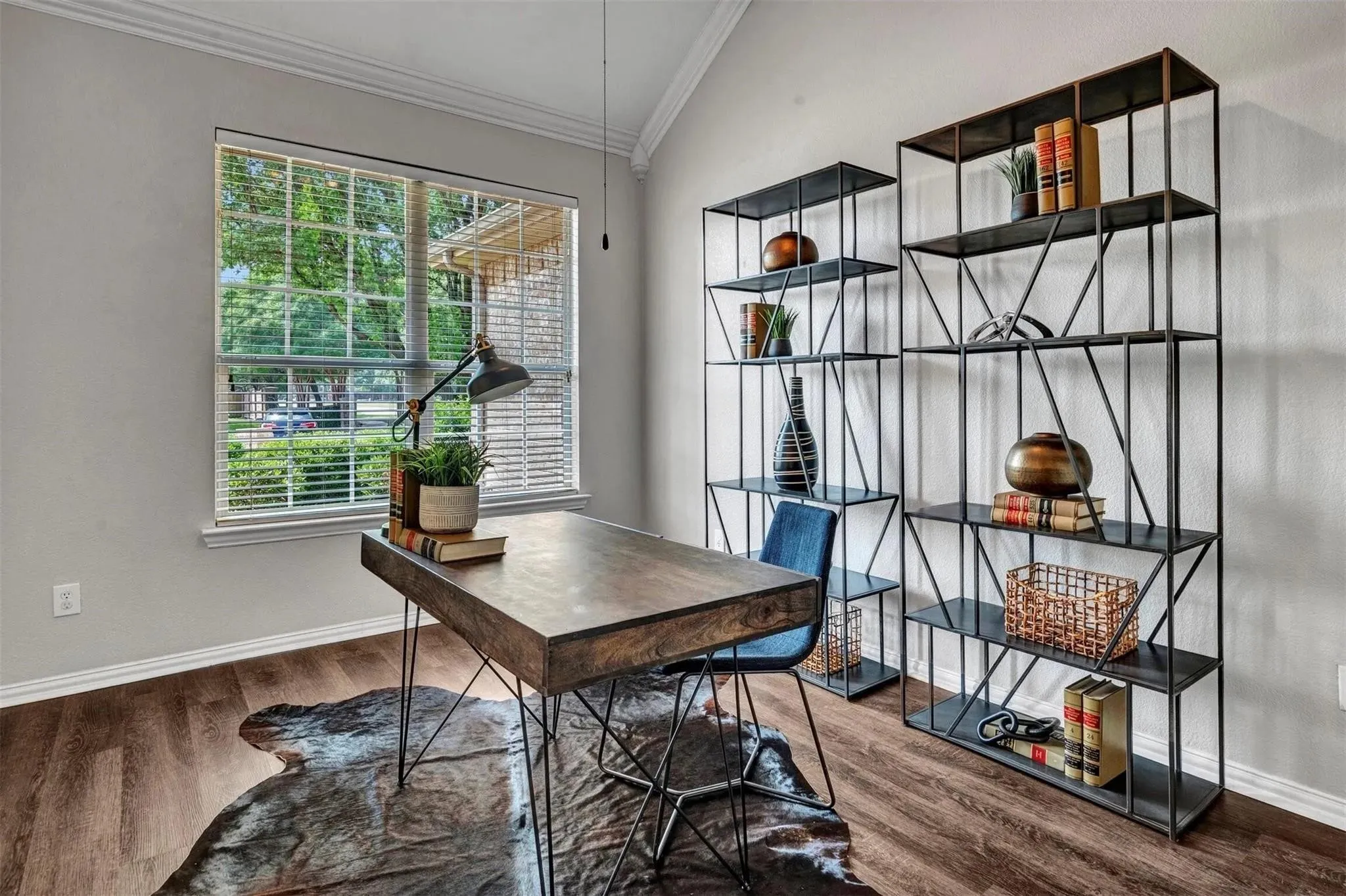 Vaulted ceiling, wood-finish flooring, large window with blinds, and built-in shelving