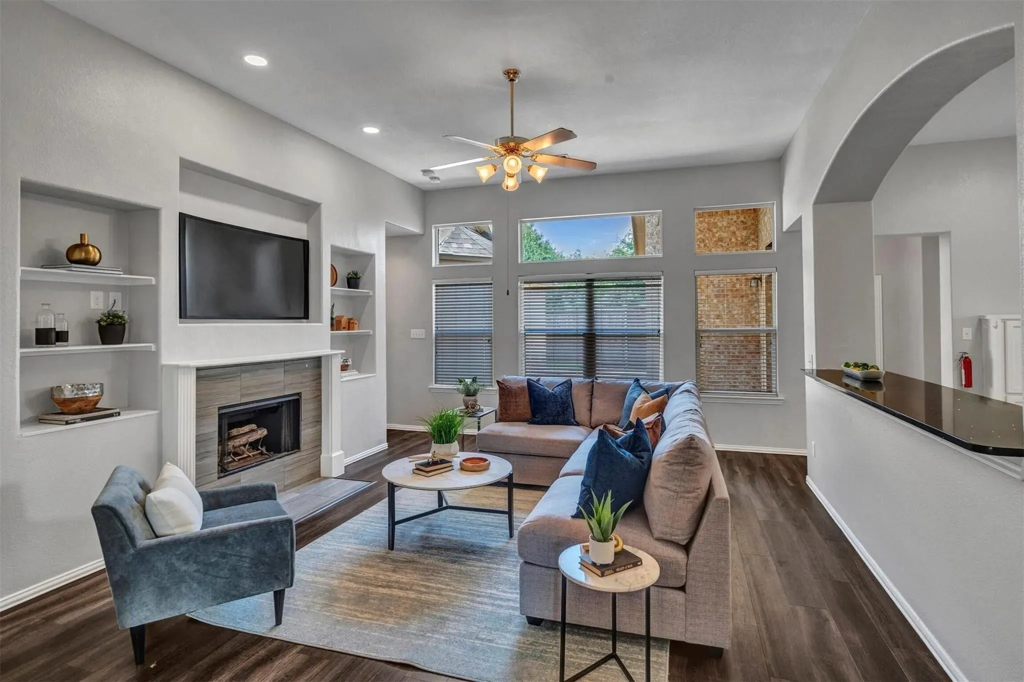 Sophisticated living room showcasing hardwood flooring, a linear gas fireplace with built-in cabinetry, and recessed ceiling lighting