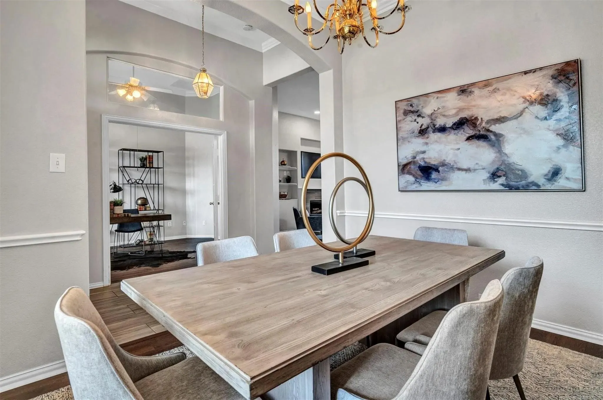 Formal dining area with wood-finish flooring, an ornate chandelier, and arched entryway