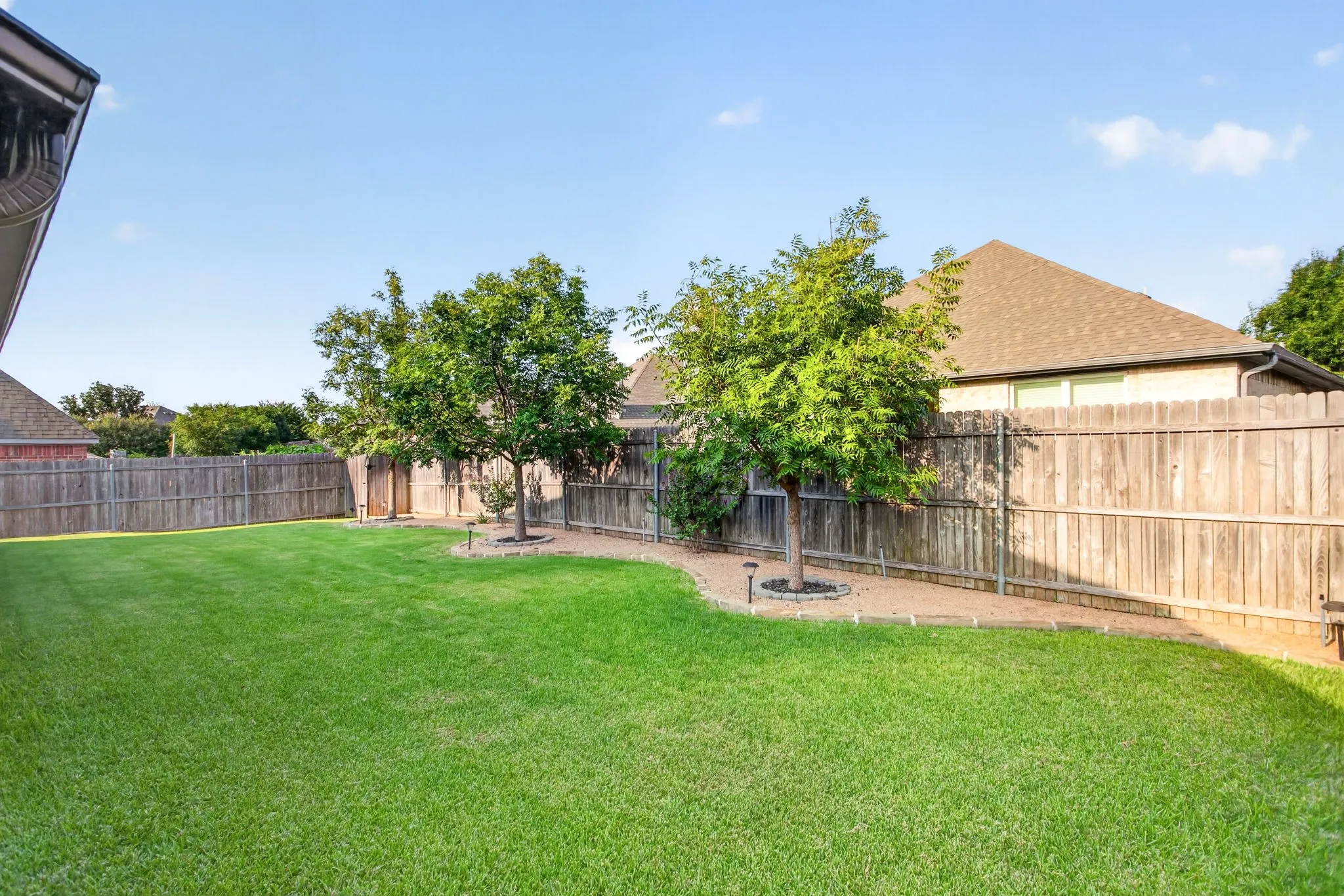 Manicured yard and three trees