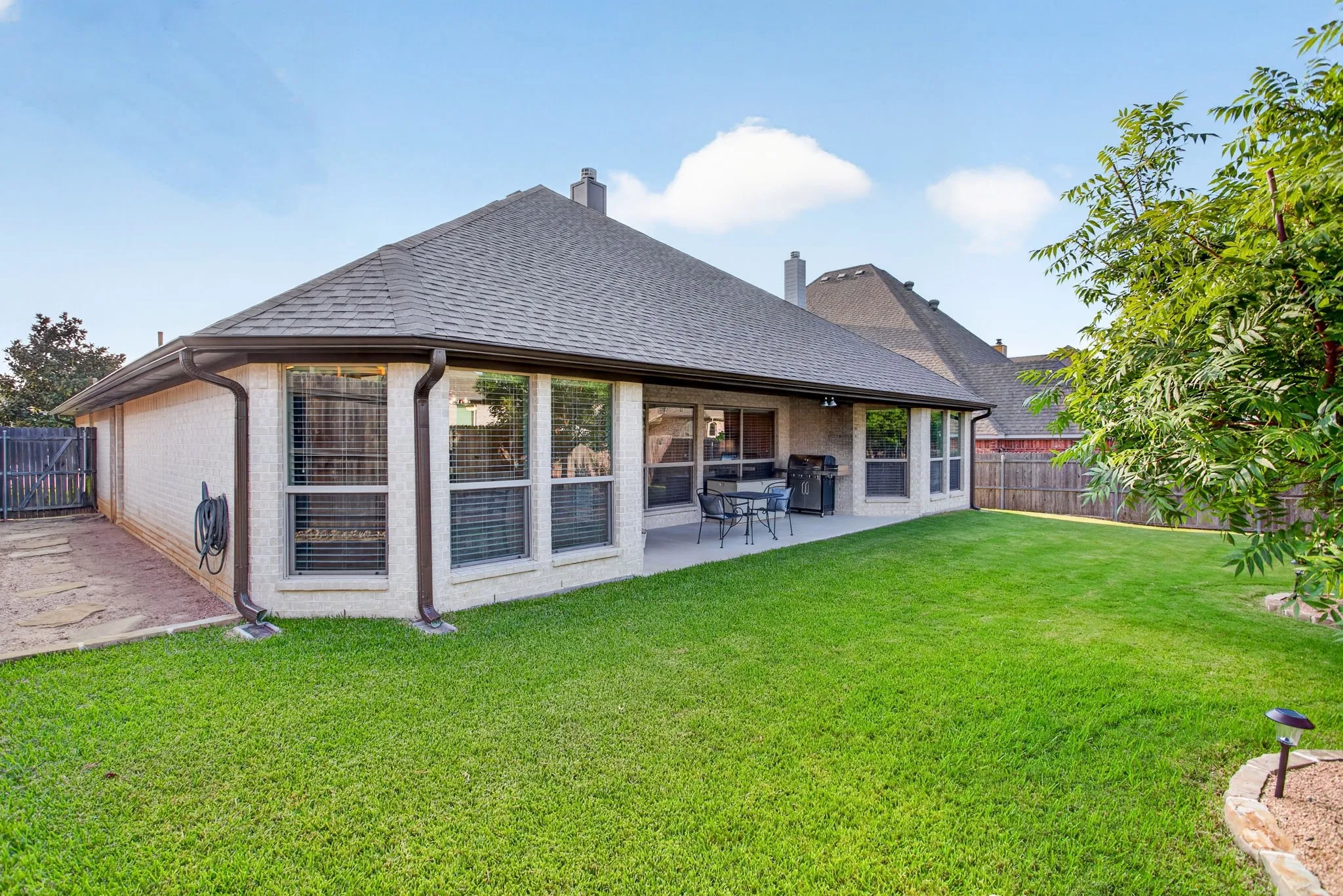 Low maintenance back yard with grass and trees