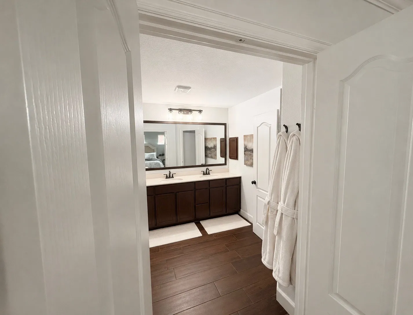 Bathroom featuring a dual vanity with a dark wood-finish cabinet and light-toned countertop