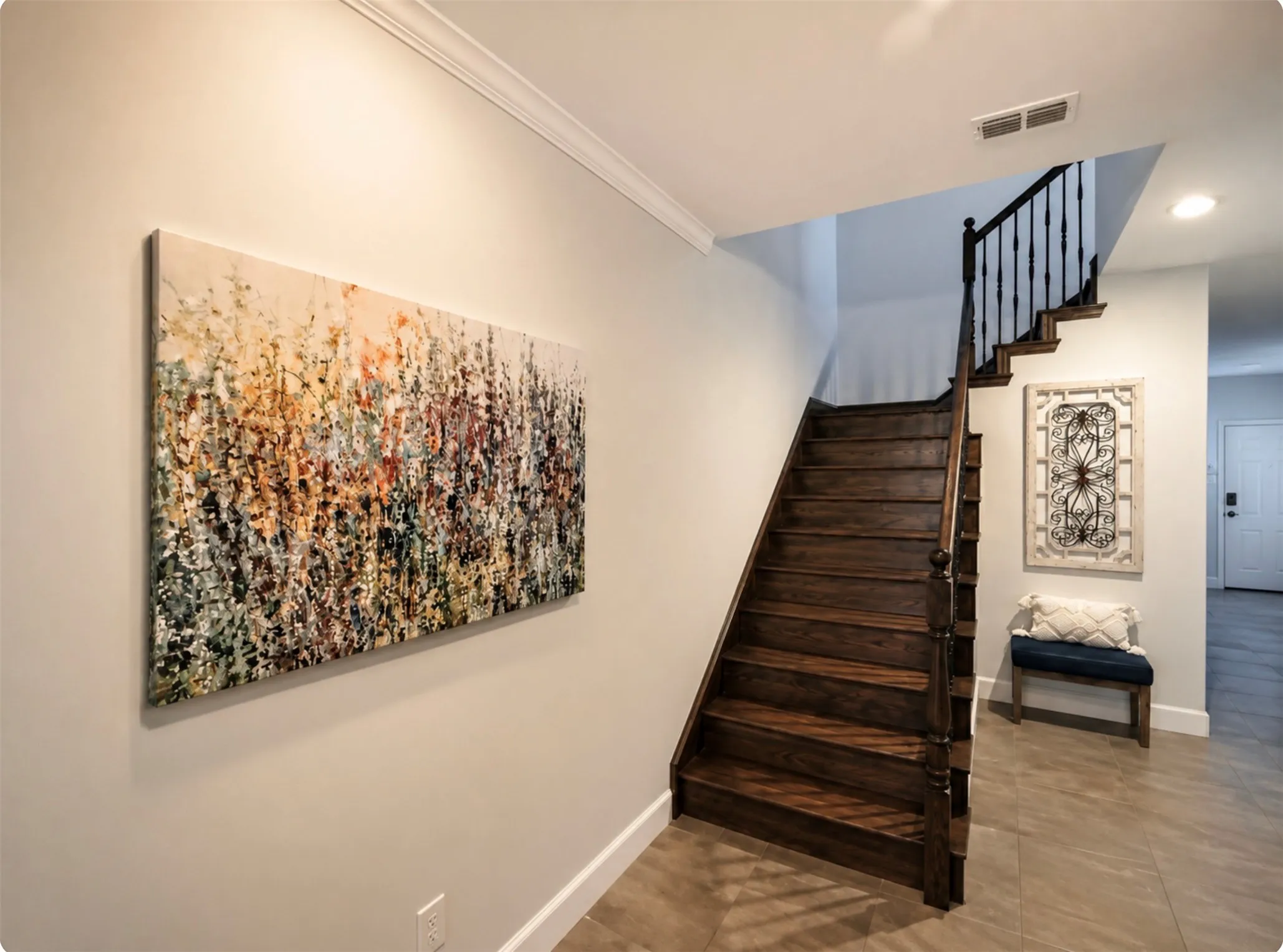 Hardwood staircase featuring dark wood treads and a black metal baluster railing system