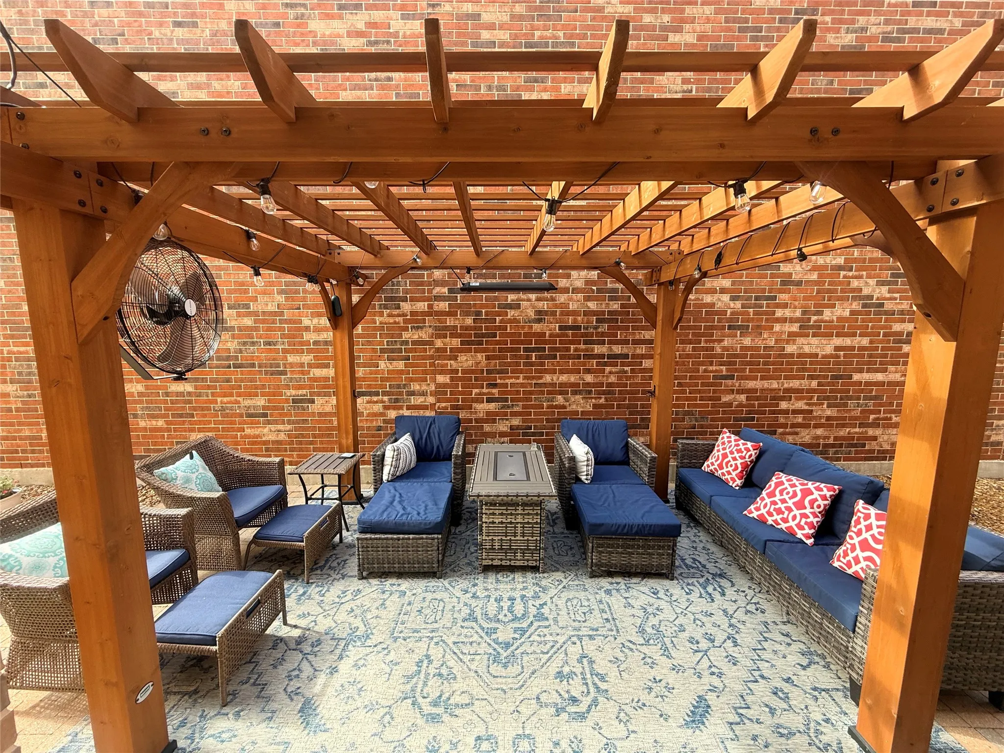 Expansive wood pergola featuring string lighting, a mounted fan, and an infrared heater