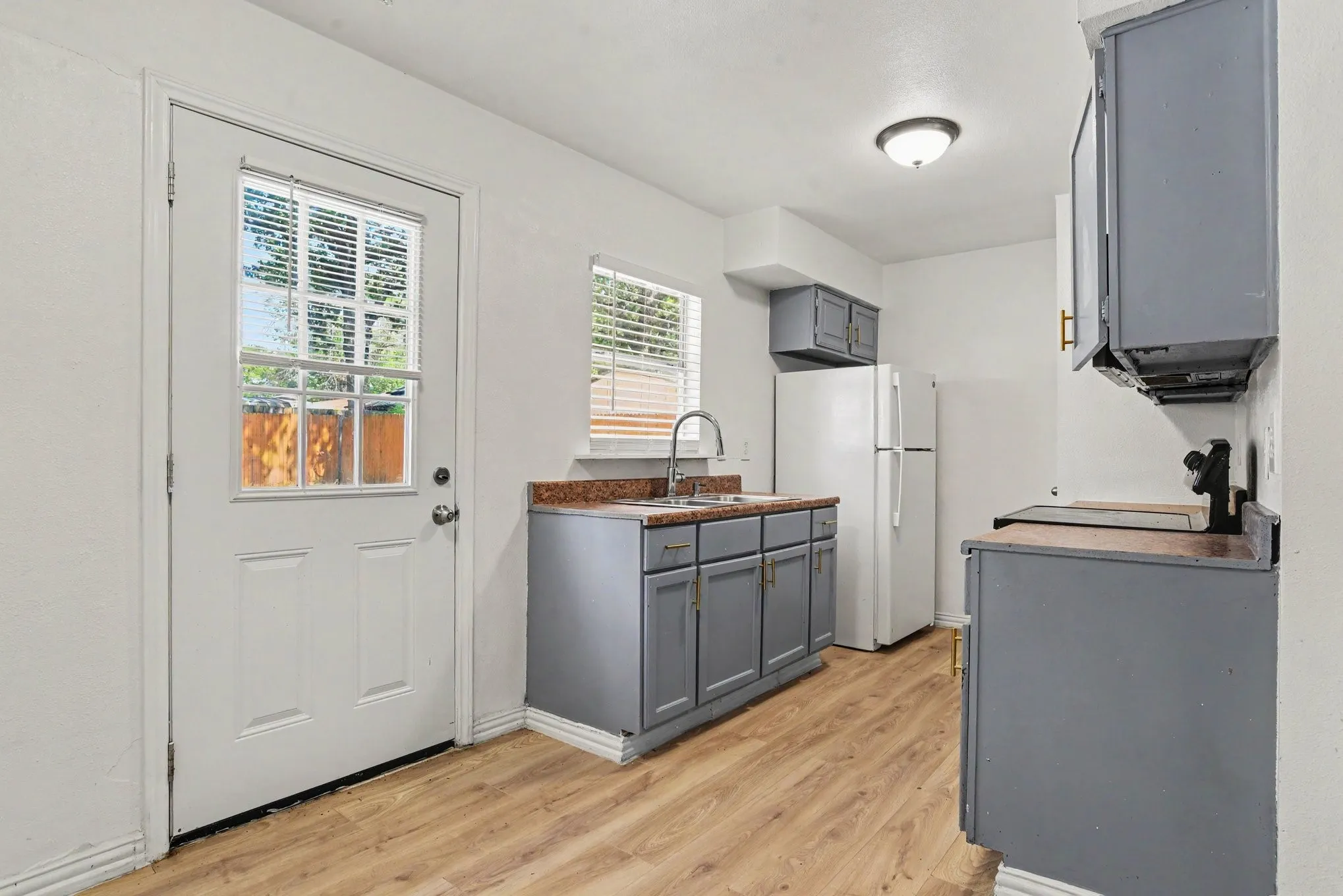 Kitchen angle displaying countertop space, lower storage cabinets, and direct access door to the exterior.