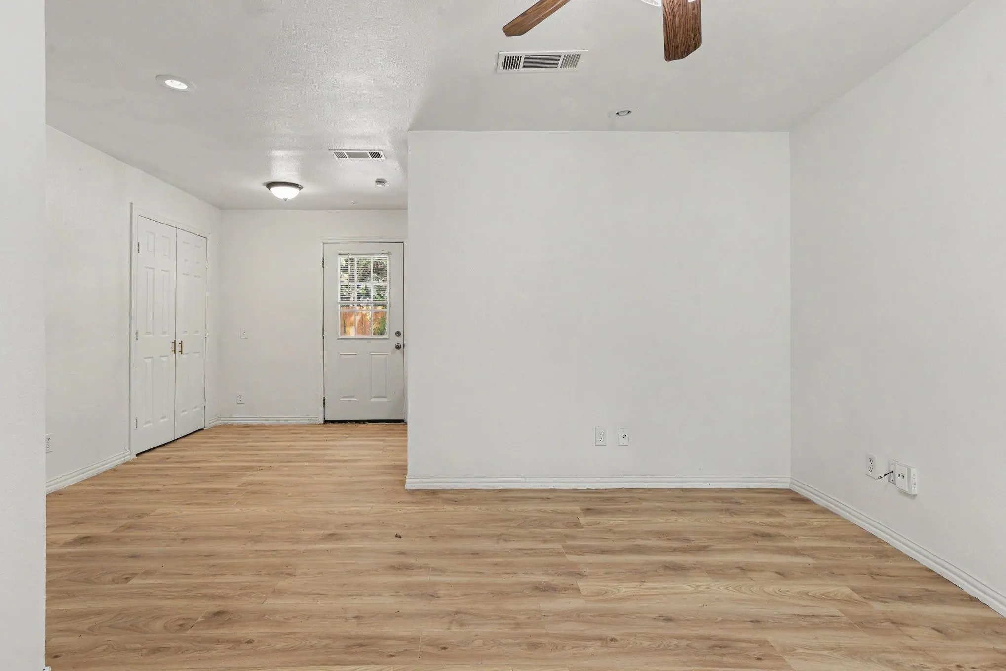 Spacious interior hall and living area displaying neutral finishes and clean recessed layout.