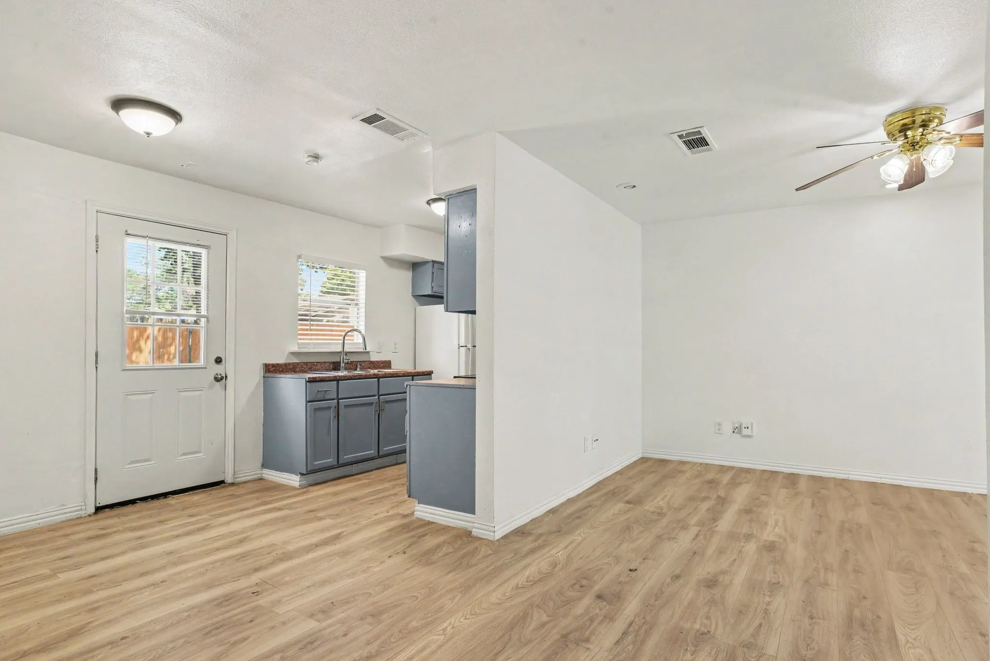 Open-concept living space seamlessly connecting to the kitchen, complete with back exit door access.