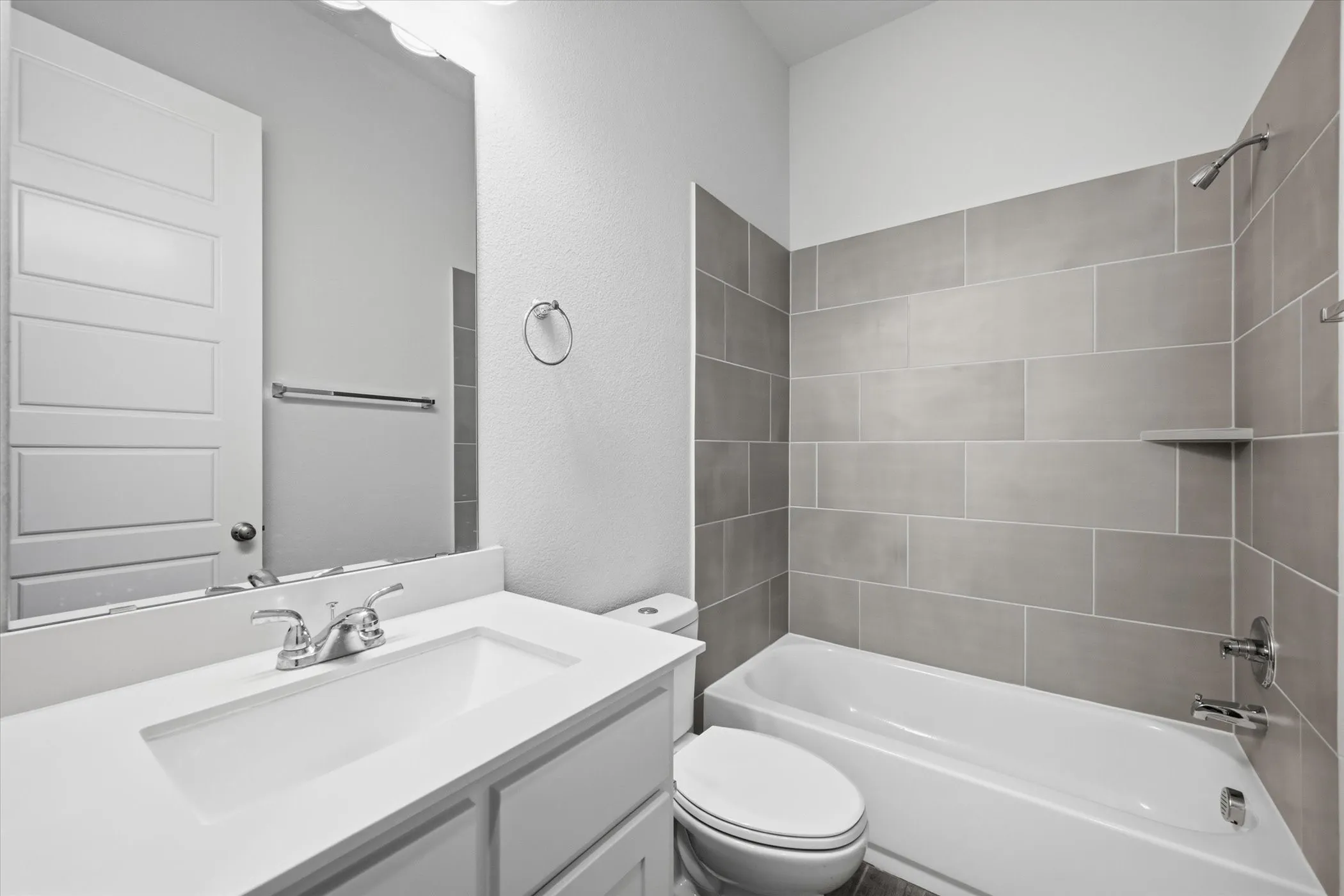 Modern bathroom featuring a single vanity with integrated sink, chrome faucet, and a large mirror