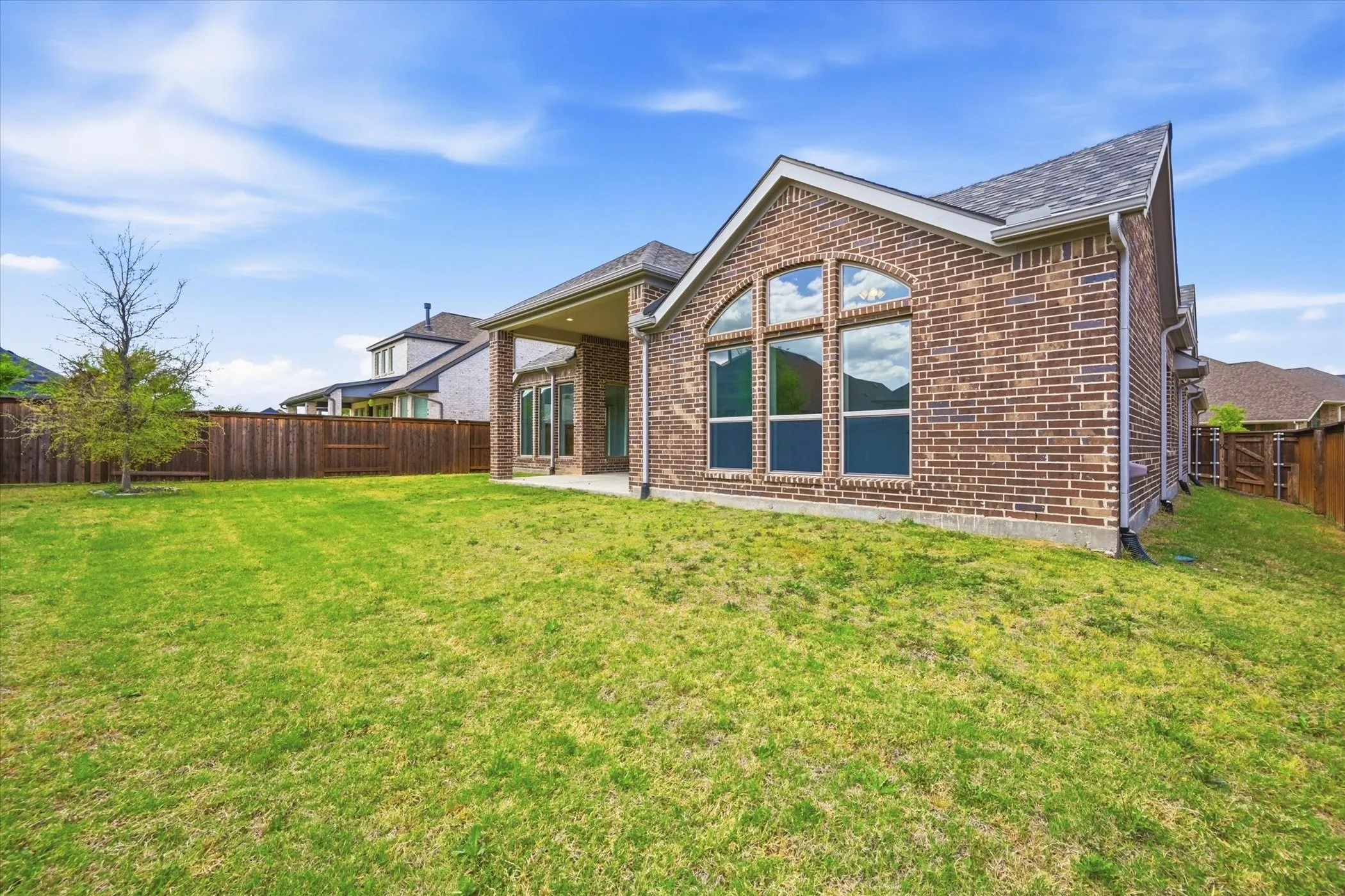 Expansive green lawn with a privacy fence