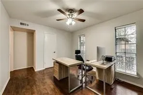 Hardwood-finish flooring, recessed alcove, ceiling fan with integrated lighting, two windows with blinds, and painted walls