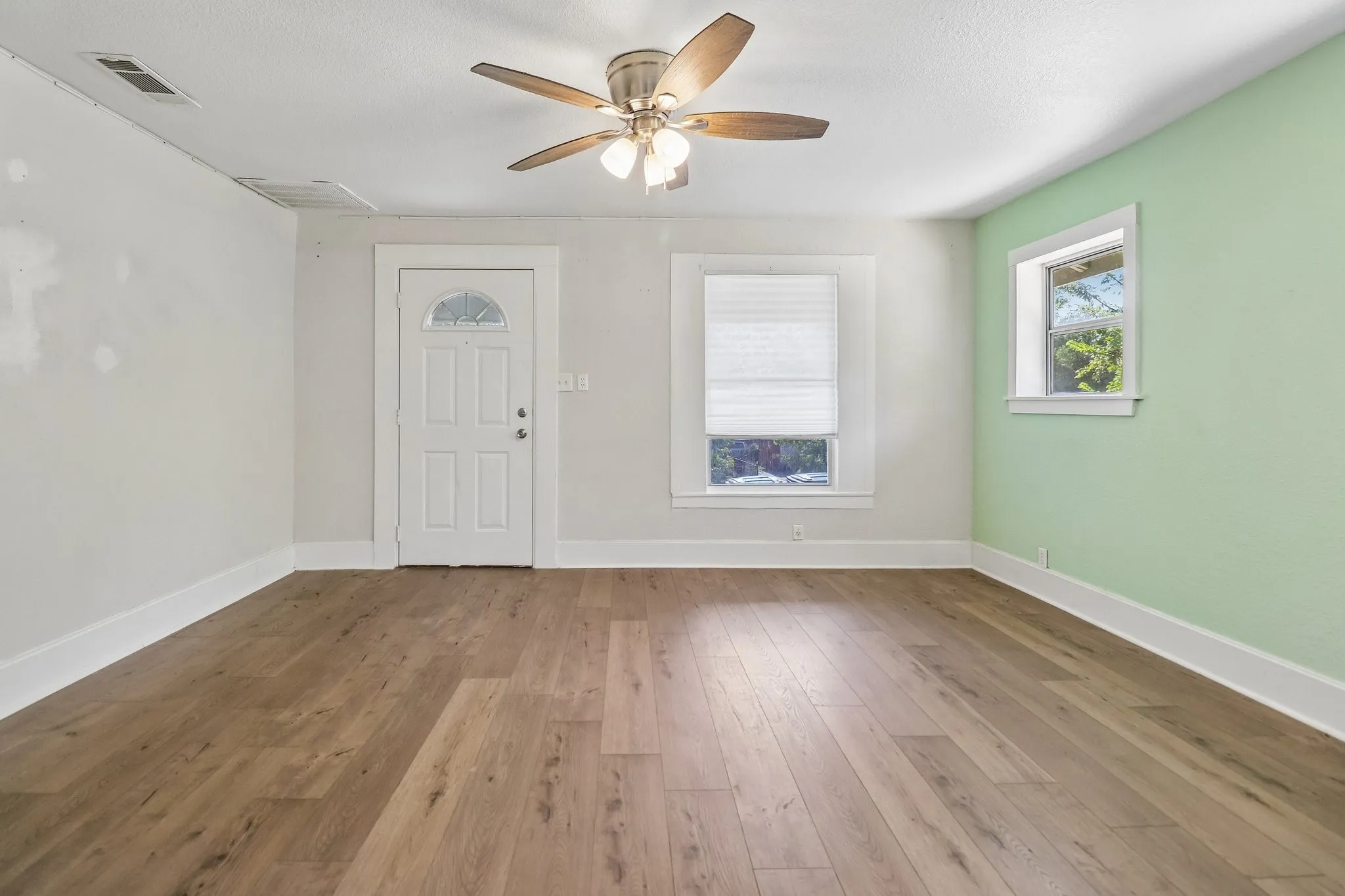 Wood-finish flooring throughout, complemented by a ceiling fan with integrated lighting