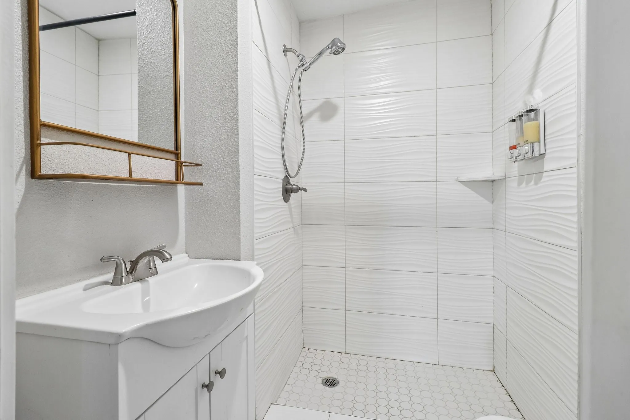 White vanity with integrated sink, brushed nickel faucet, and framed mirror
