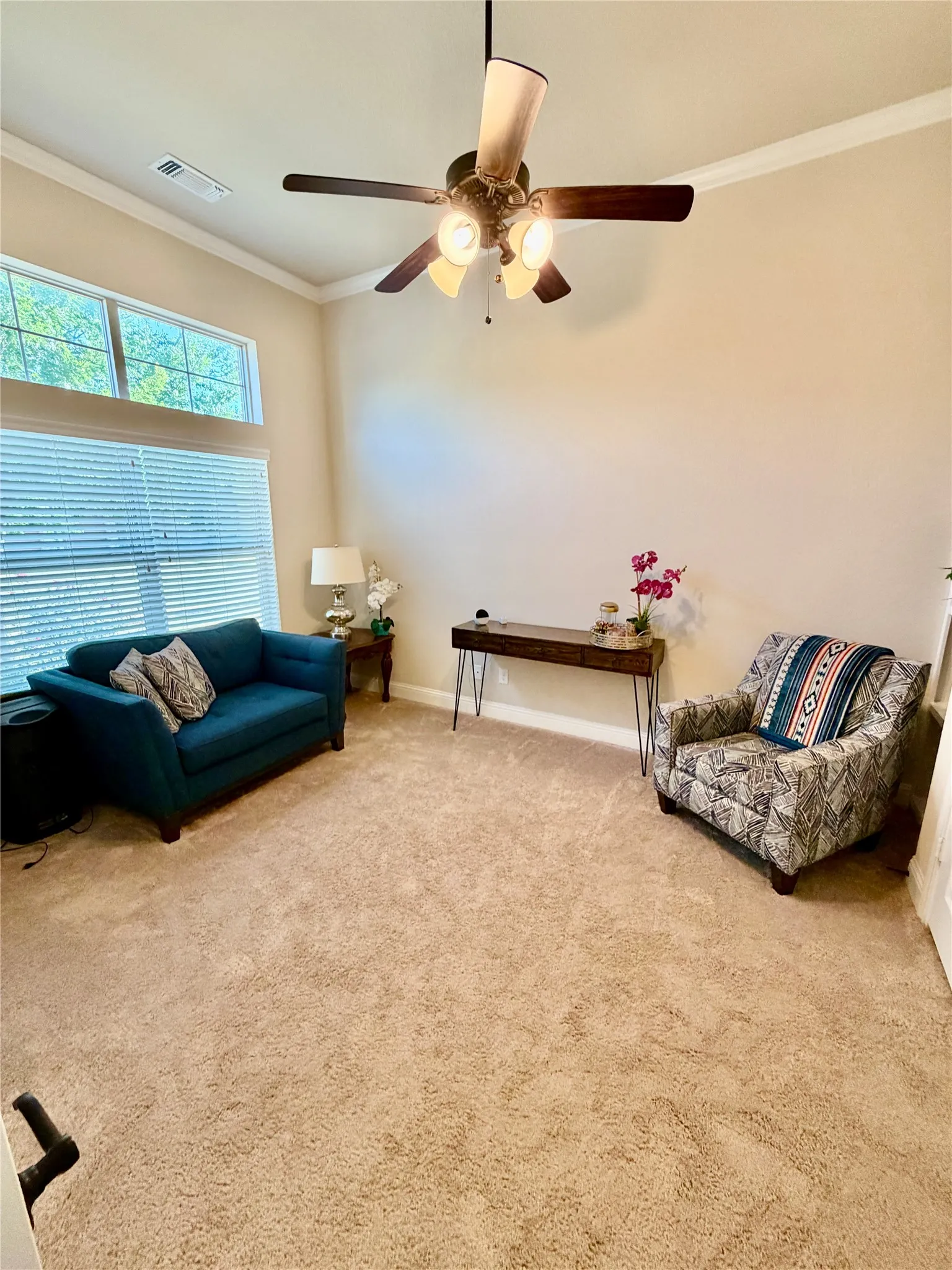 Vaulted ceiling, high transom window, recessed window, ceiling fan with integrated lighting, and neutral carpet