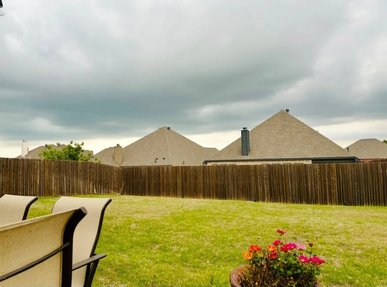 Expansive backyard featuring a lush green lawn, full privacy fencing, and ample space for outdoor activities