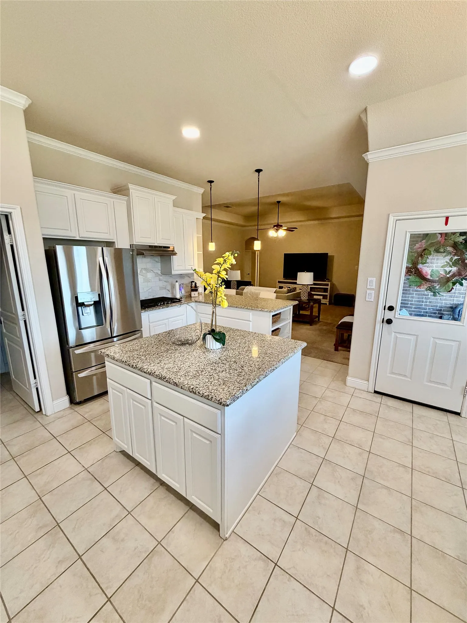 Kitchen featuring two islands with granite countertops, stainless steel appliances, white cabinetry, and recessed lighting