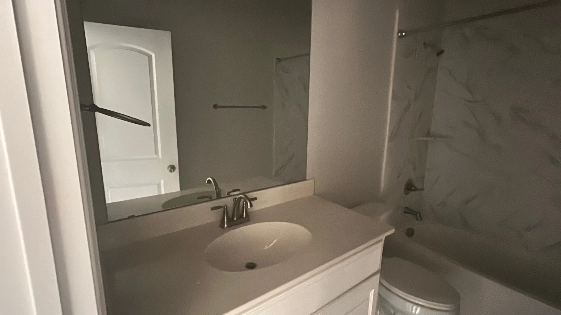 White vanity with integrated sink, chrome faucet, and expansive wall mirror