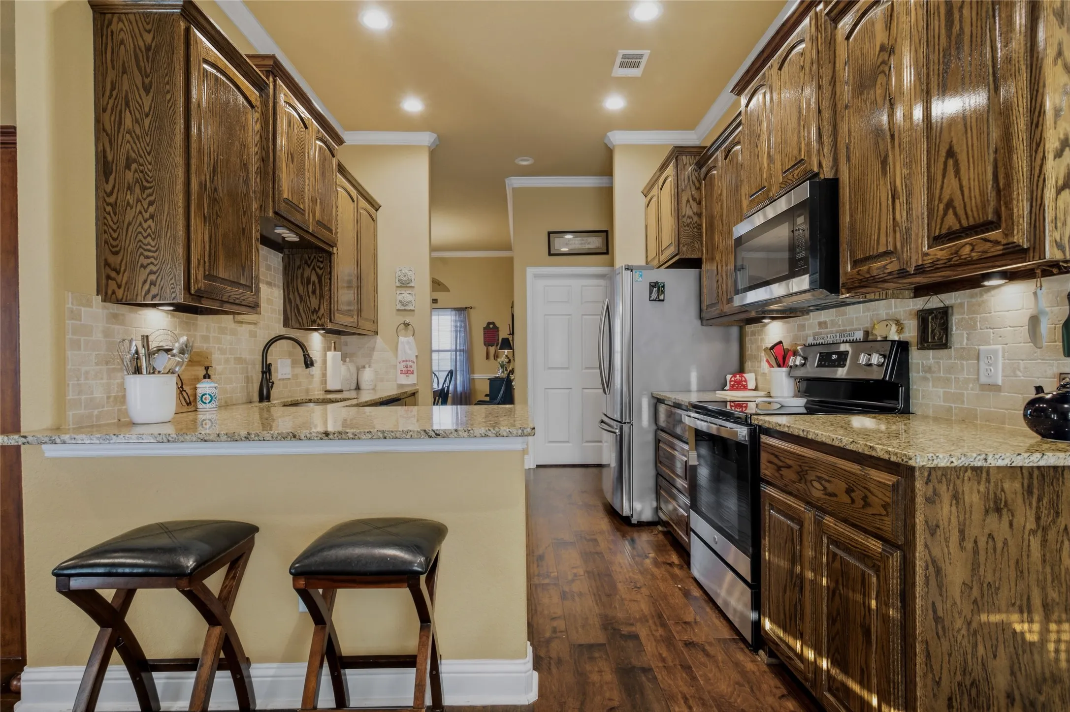 From west side view, you can see back through the kitchen to the dining room.  There is a walk-in pantry on the right and the white door you see leads to the laundry room.