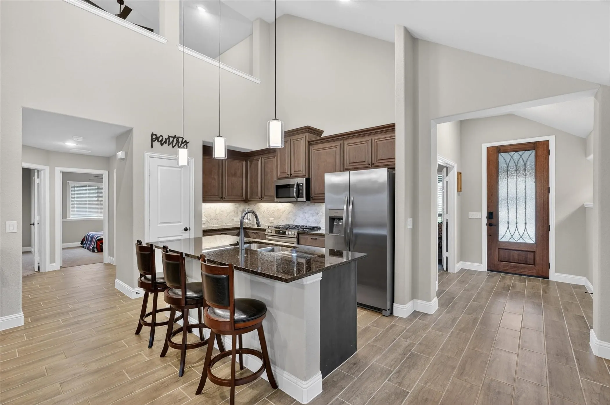 Kitchen featuring a large island with countertop seating, dark wood cabinetry, and stainless steel appliances