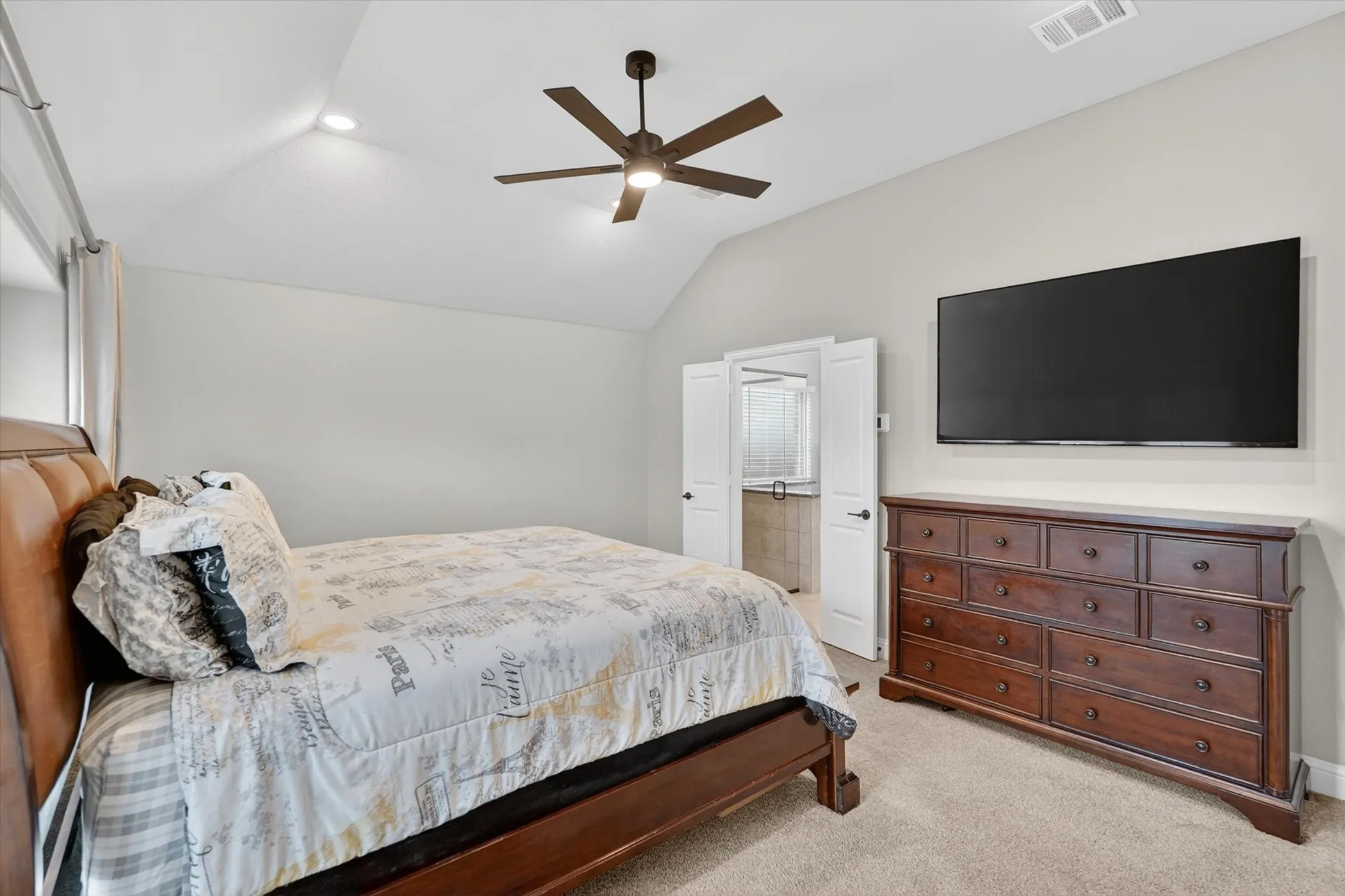 Vaulted ceiling with recessed lighting and a ceiling fan