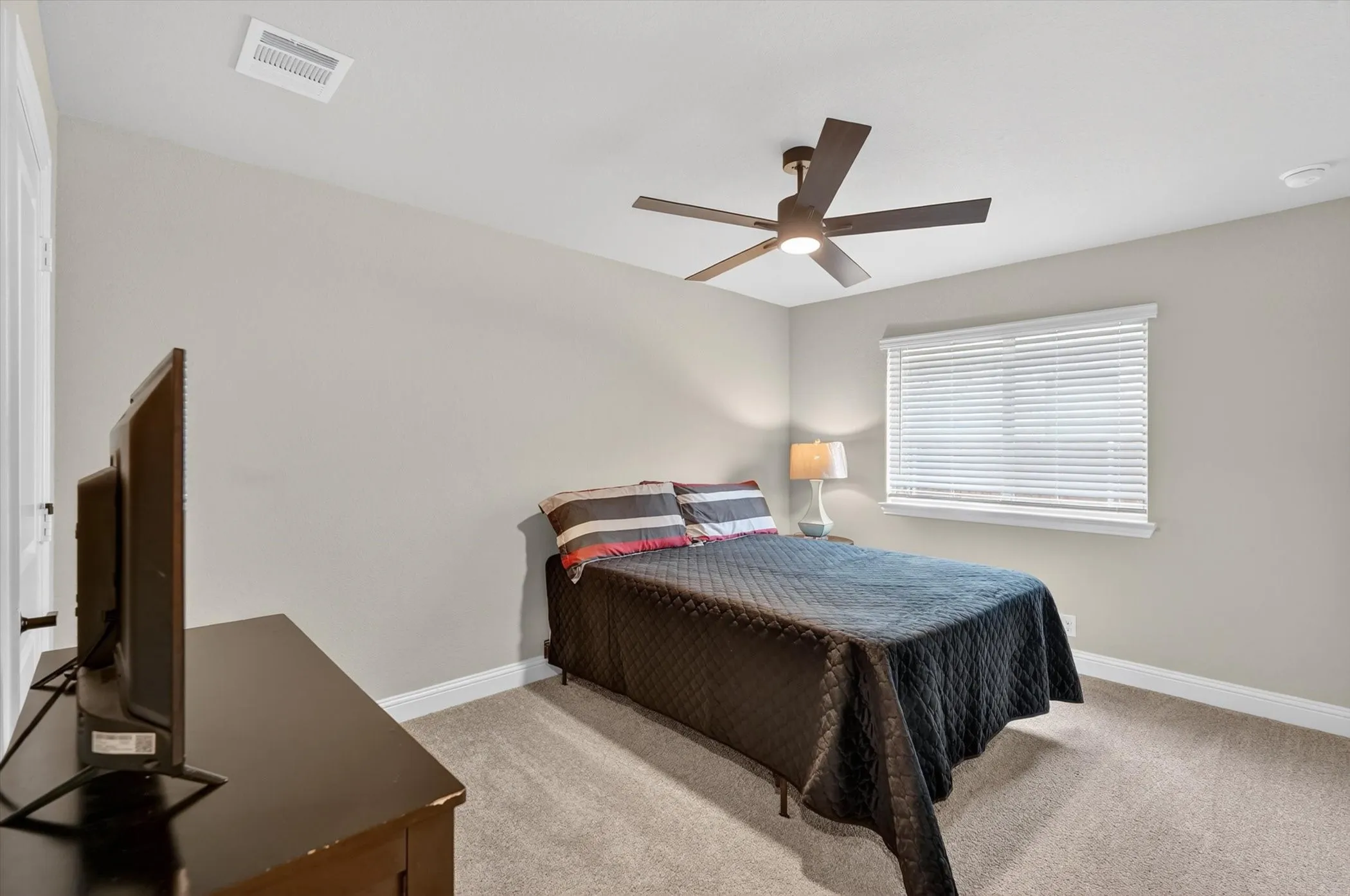Wall-to-wall carpeting, window with blinds, ceiling fan with light fixture, and neutral wall paint