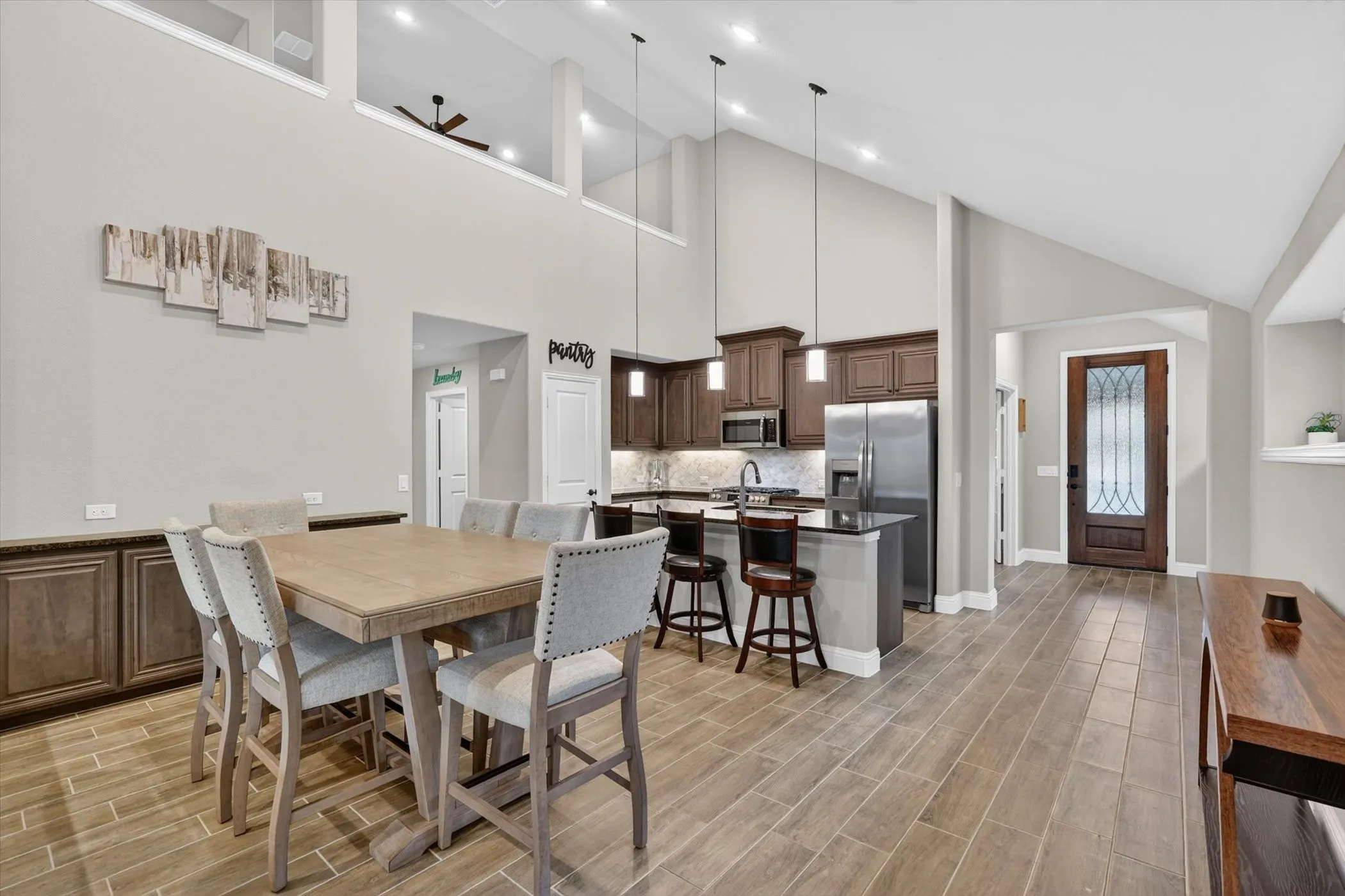 Open-concept living area with vaulted ceilings, wood-finish flooring, and recessed lighting