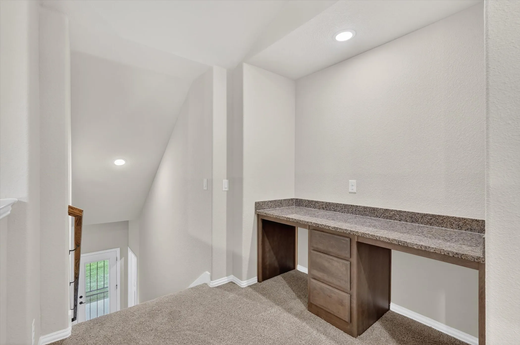 Built-in desk with a stone-finish countertop and integrated storage drawers