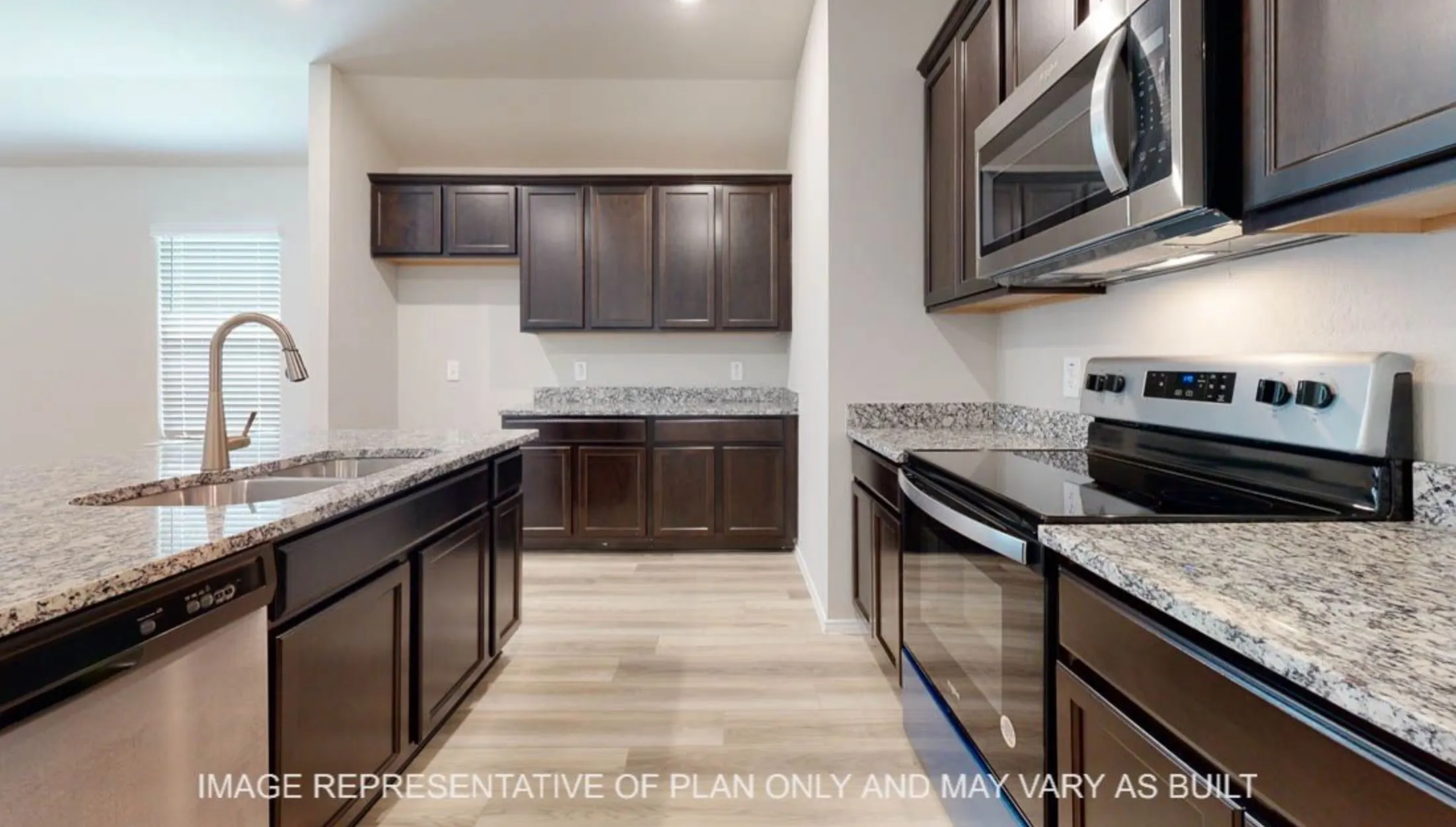 Kitchen featuring wood-finish flooring, dark wood cabinetry, granite countertops, a stainless steel sink with a high-arc faucet, and stainless steel appliances