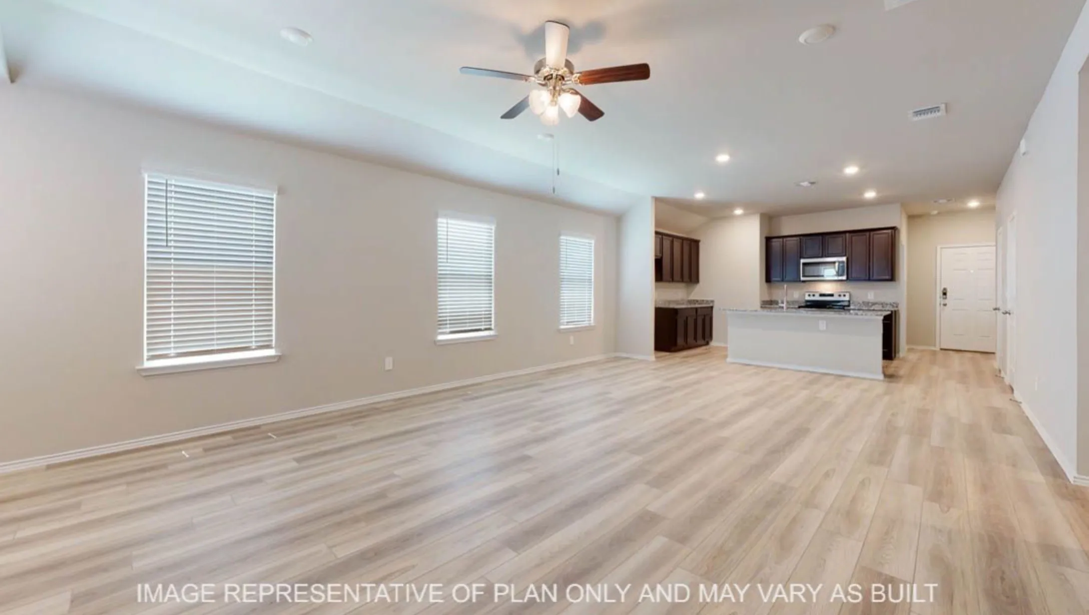 Open-concept living area with wood-finish flooring, a ceiling fan, and recessed lighting