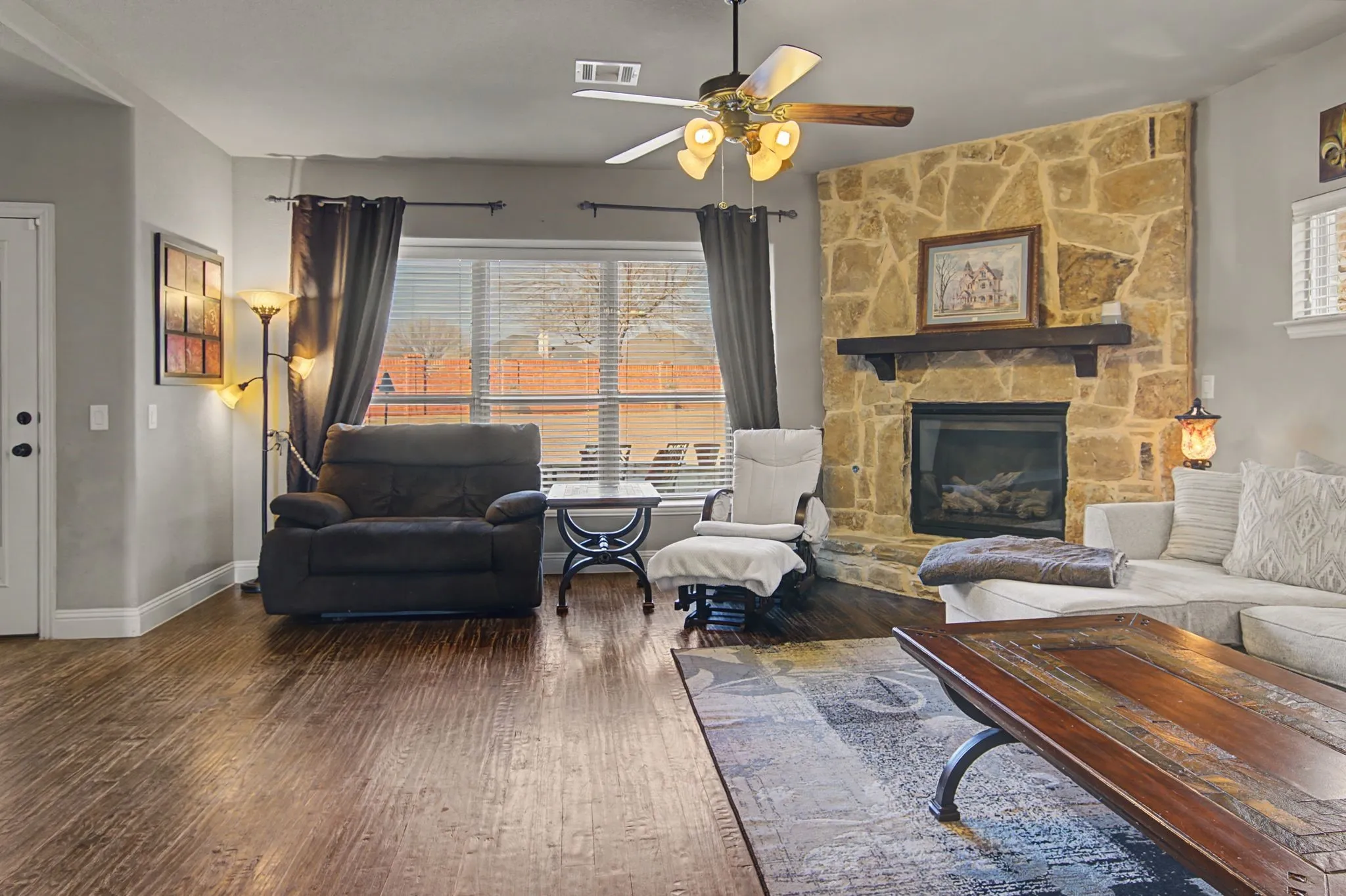 Your living room with a corner fireplace.  The windows overlook the oversized patio area with a fire pit, kitchen and plenty of room for furniture and space to play
