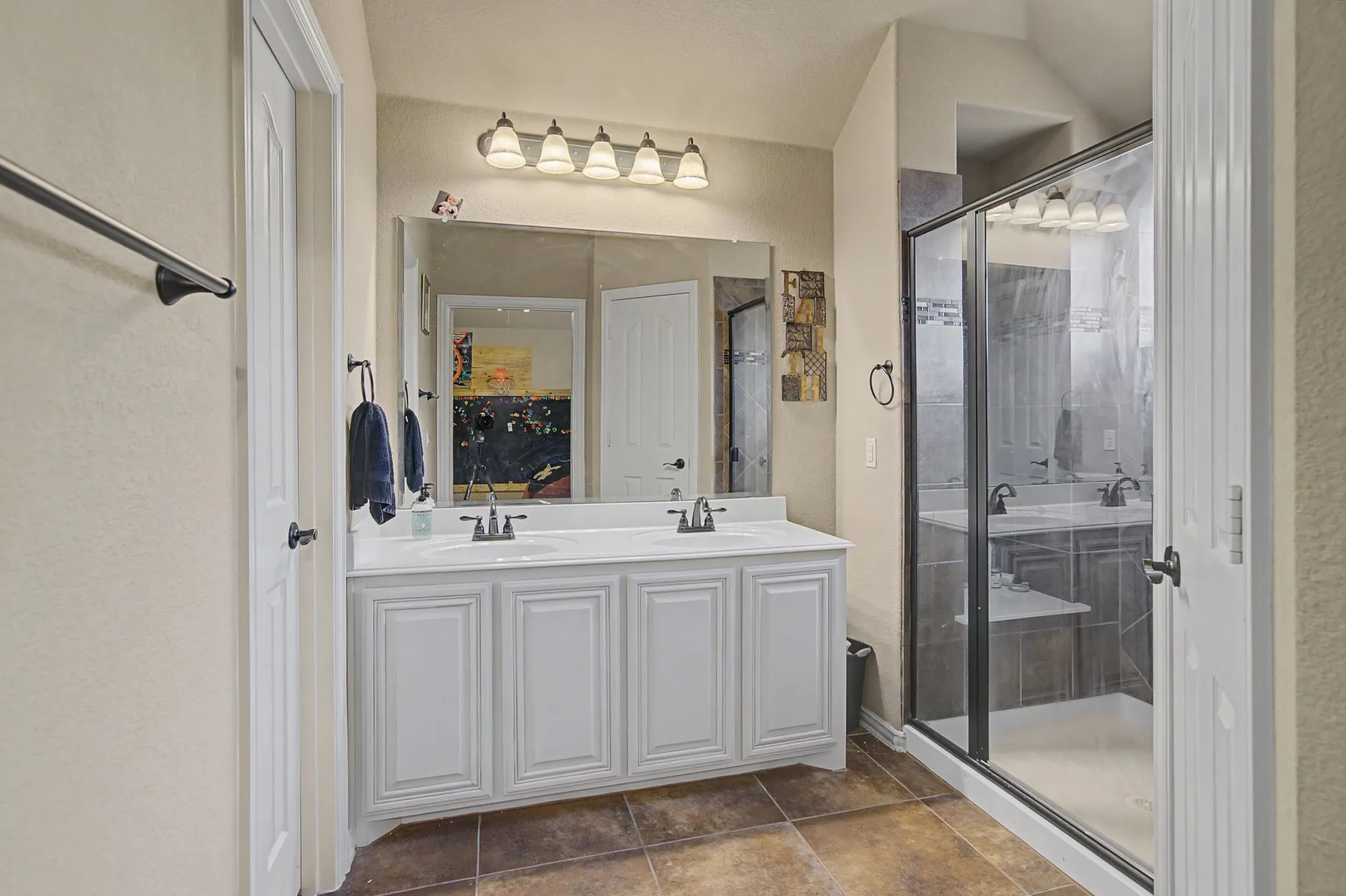 Ensuite bath of the upstairs bedroom with a walk-in closet