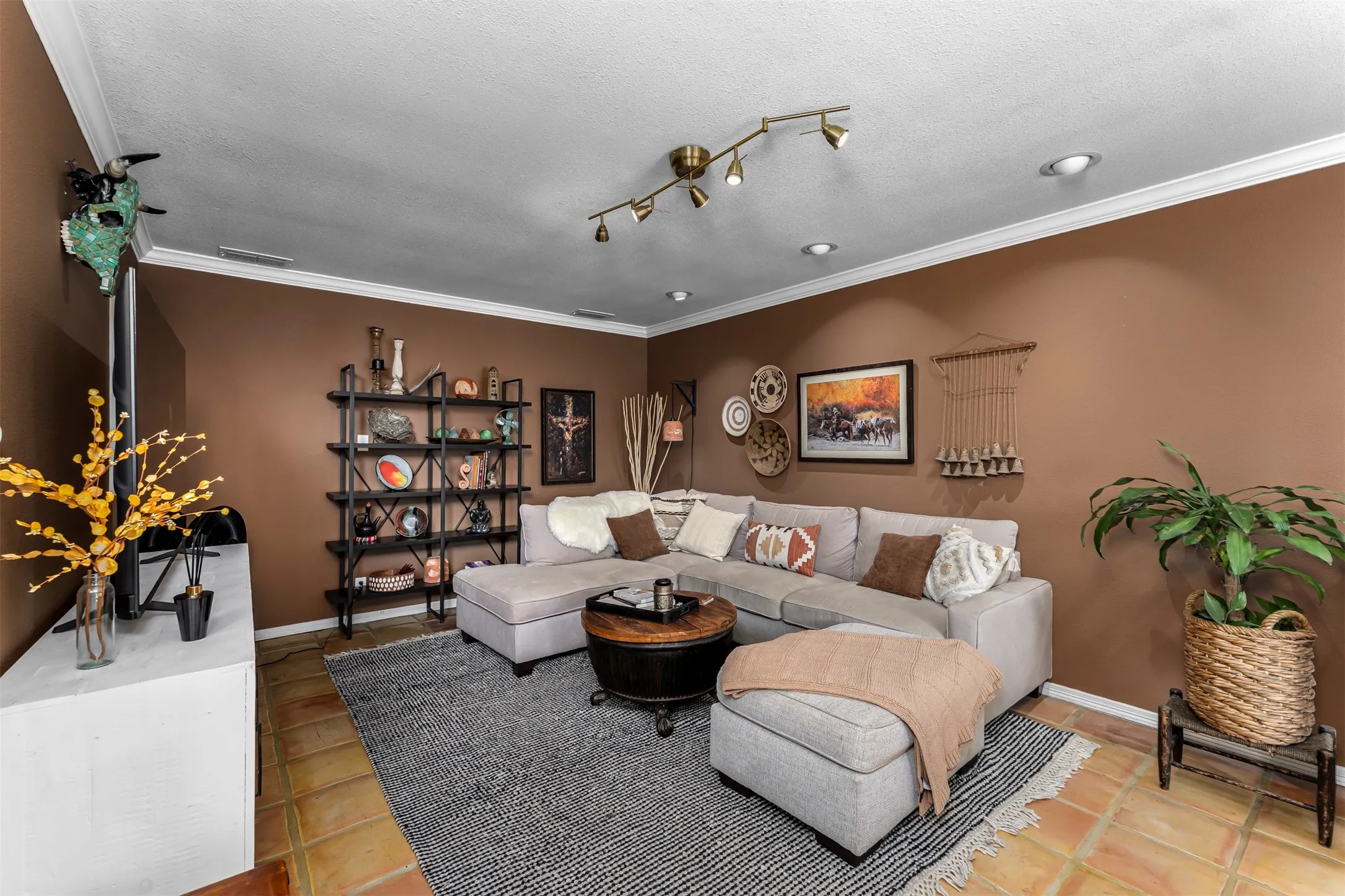 Recessed lighting, crown molding, and terracotta-style floor tiles