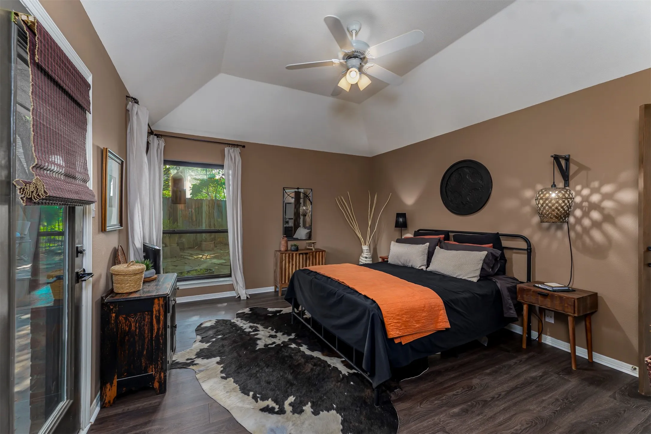 Vaulted ceiling with a ceiling fan, dark wood-finish flooring, a full-lite exterior door, and a large window