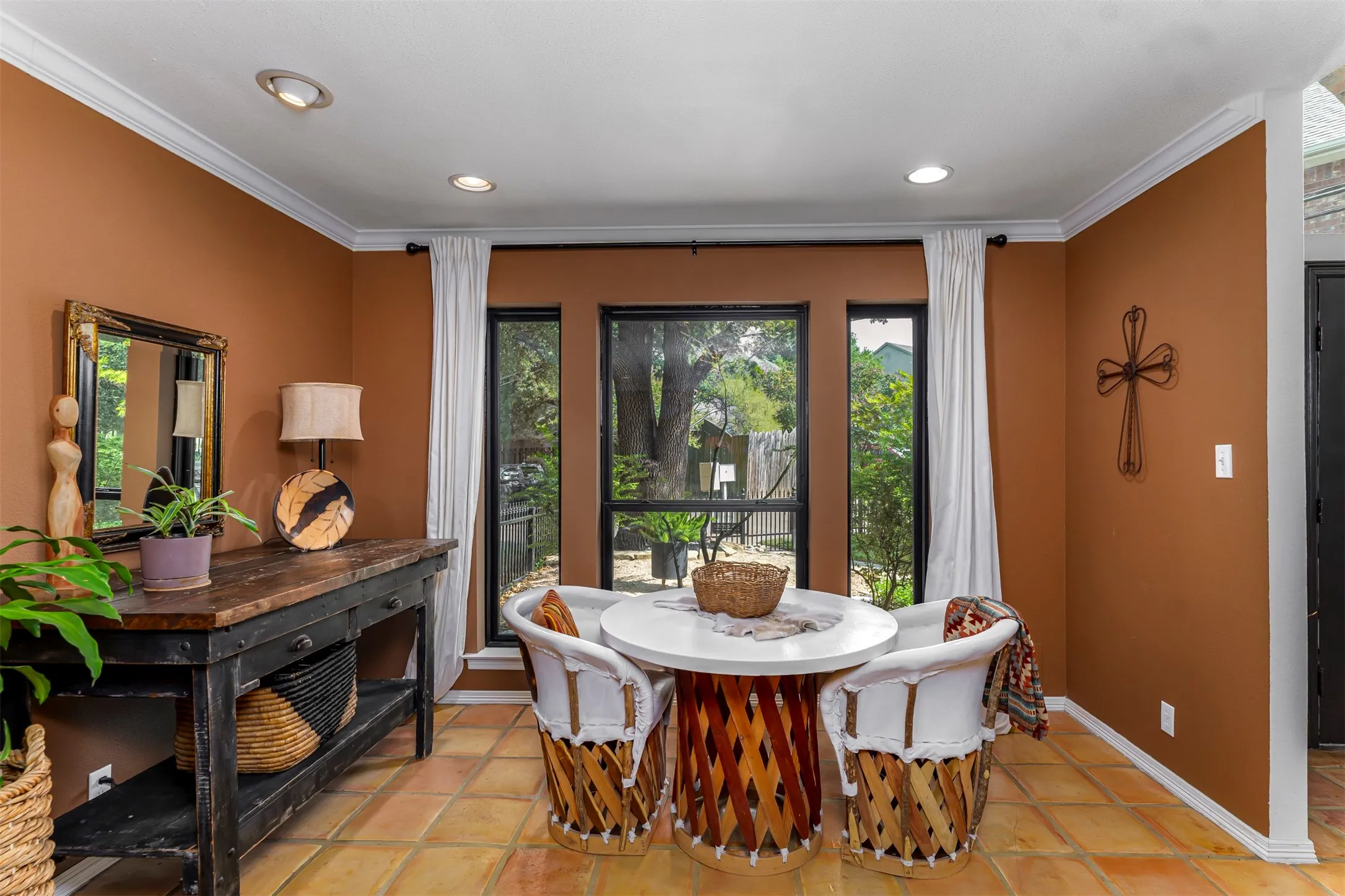 Recessed lighting, crown molding, terracotta tile flooring, and multiple windows with exterior views