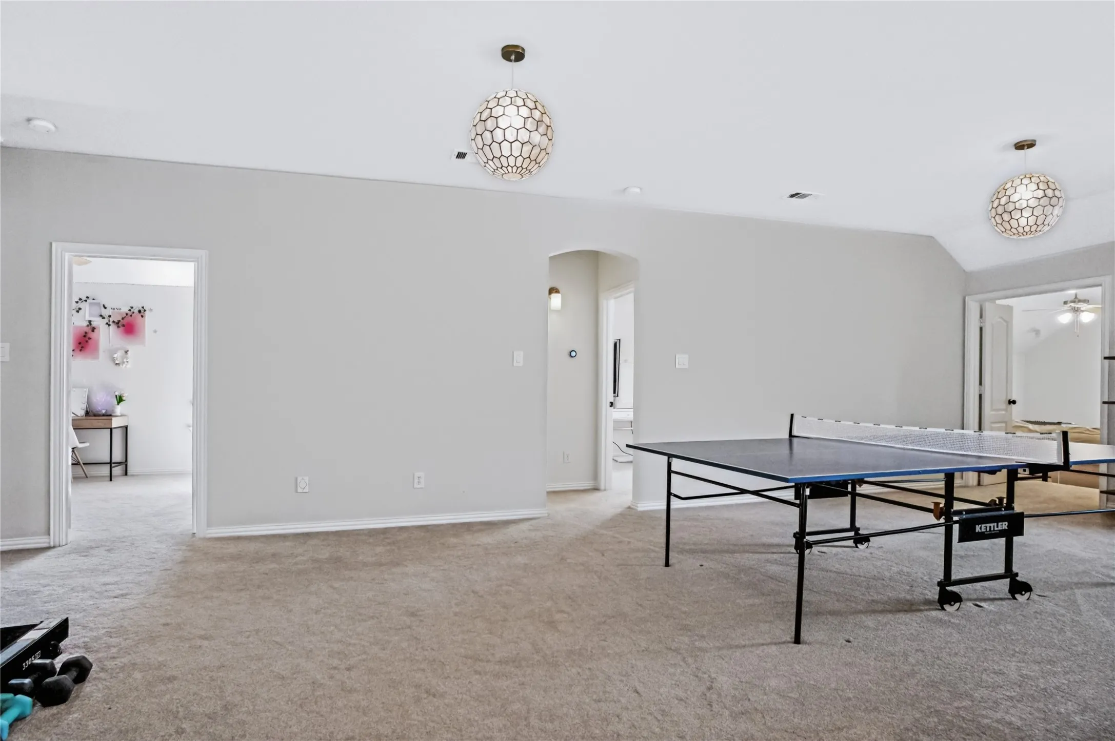 Carpeted room with vaulted ceilings and recessed lighting