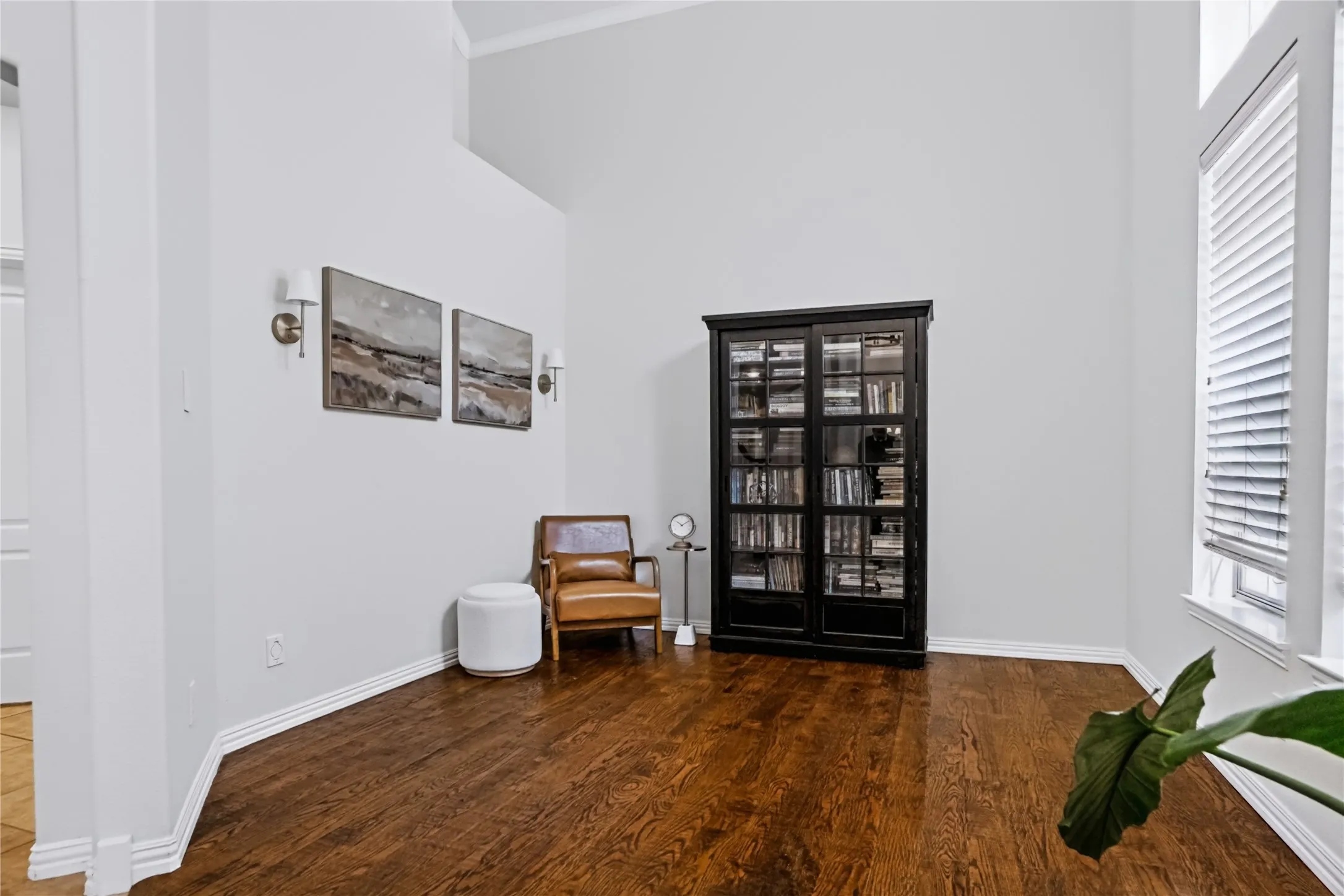 Hardwood flooring, soaring ceilings, wall sconces, window with blinds