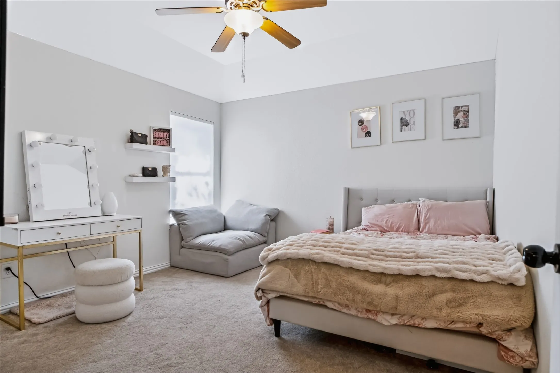 Recessed ceiling with an overhead fan, window with roller shade, and wall-mounted shelving