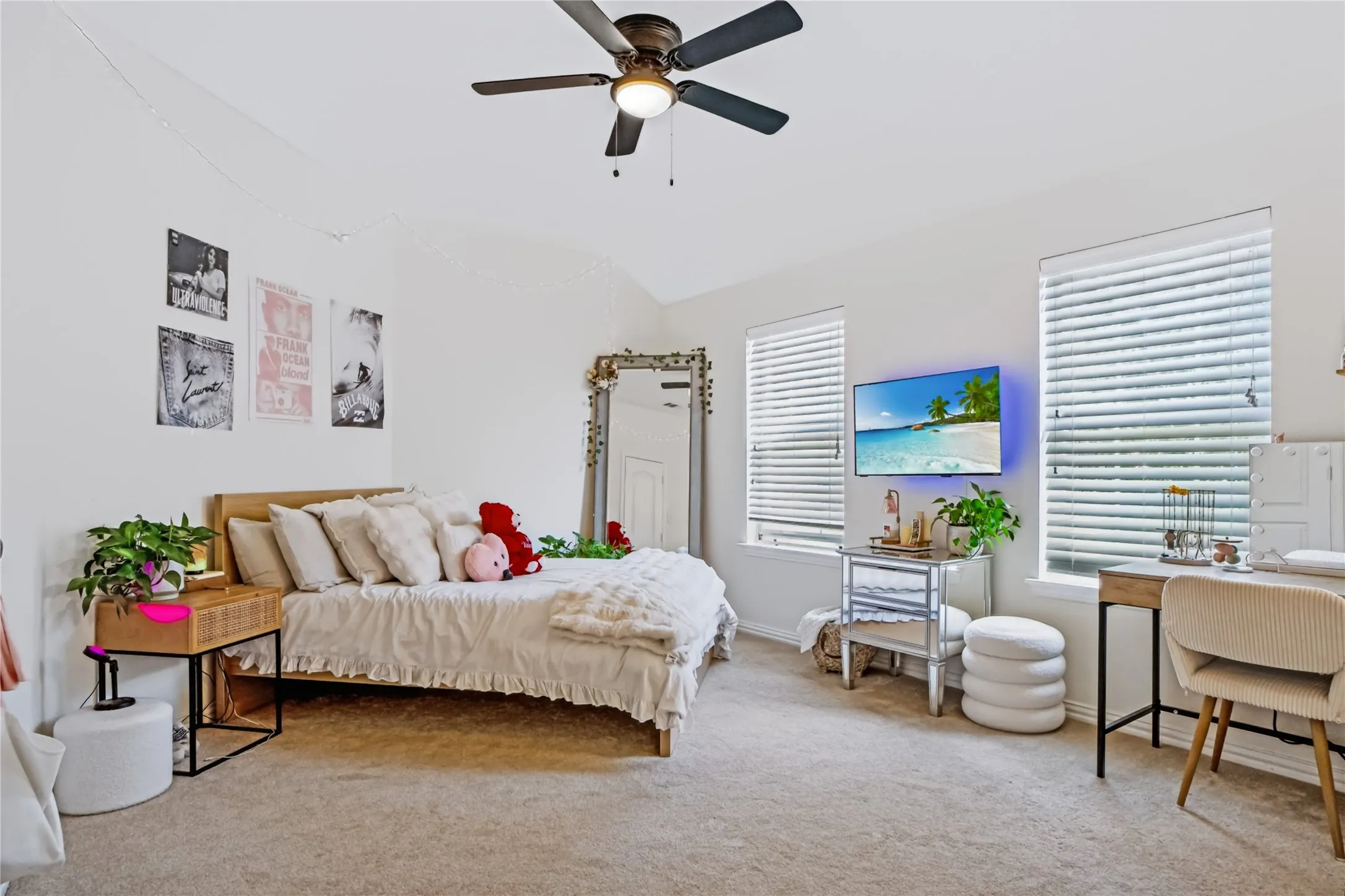 Recessed lighting, ceiling fan, two windows with blinds, wall-mounted television, and neutral-toned carpeting