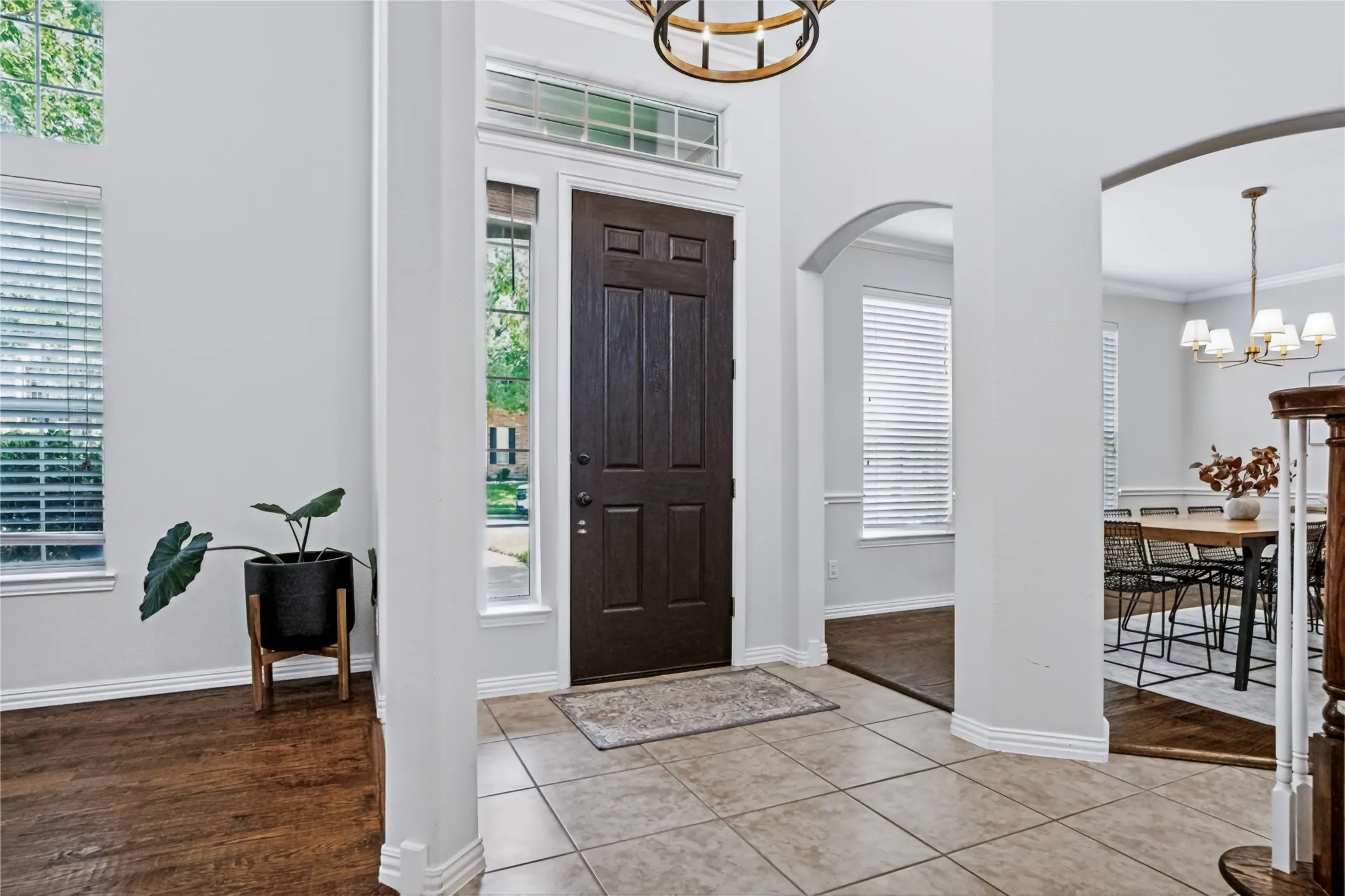 Two-story foyer with transom windows, arched doorways, and tile flooring