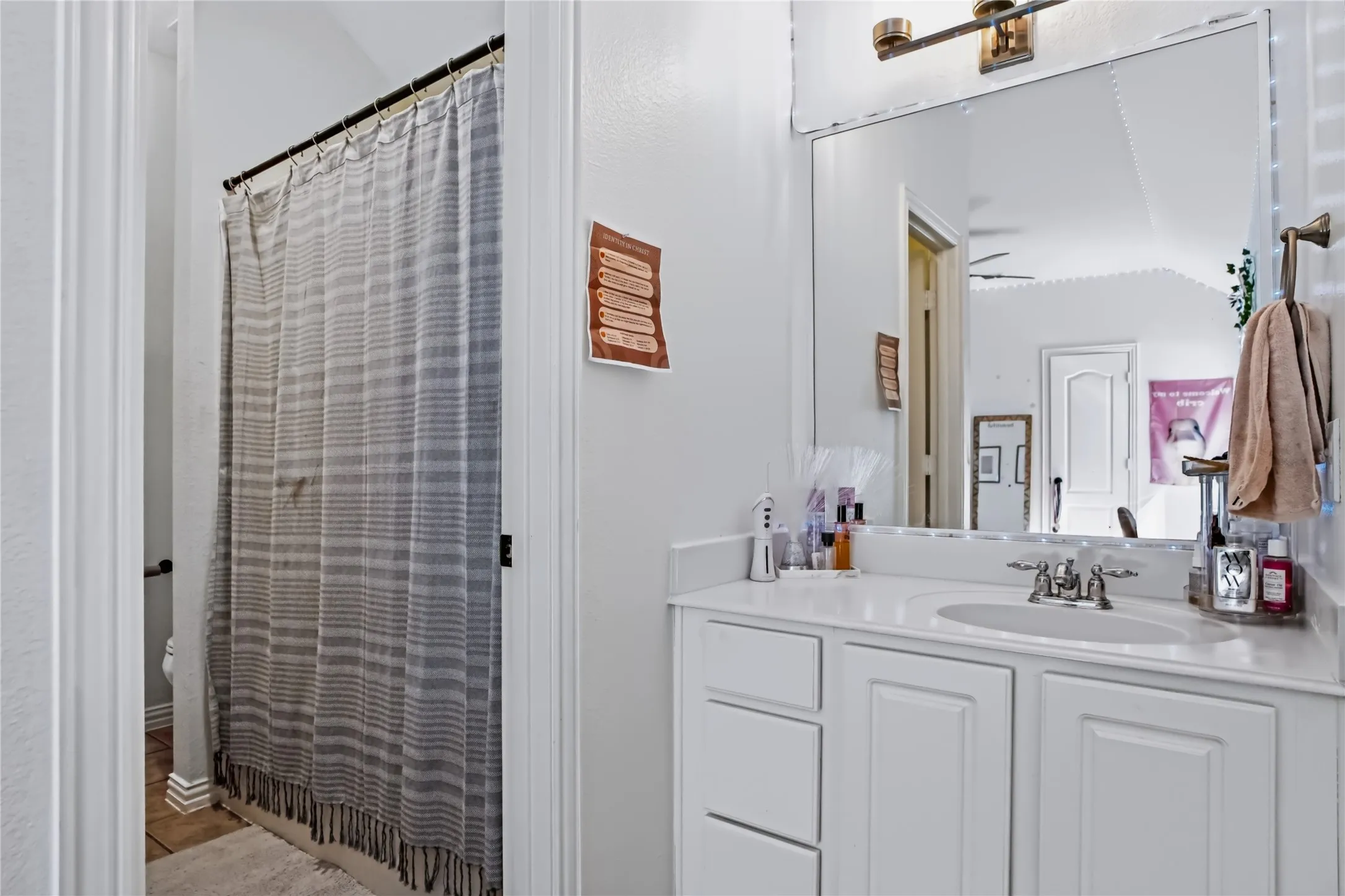 White vanity with an integrated sink, polished chrome faucet, and a wall-mounted mirror