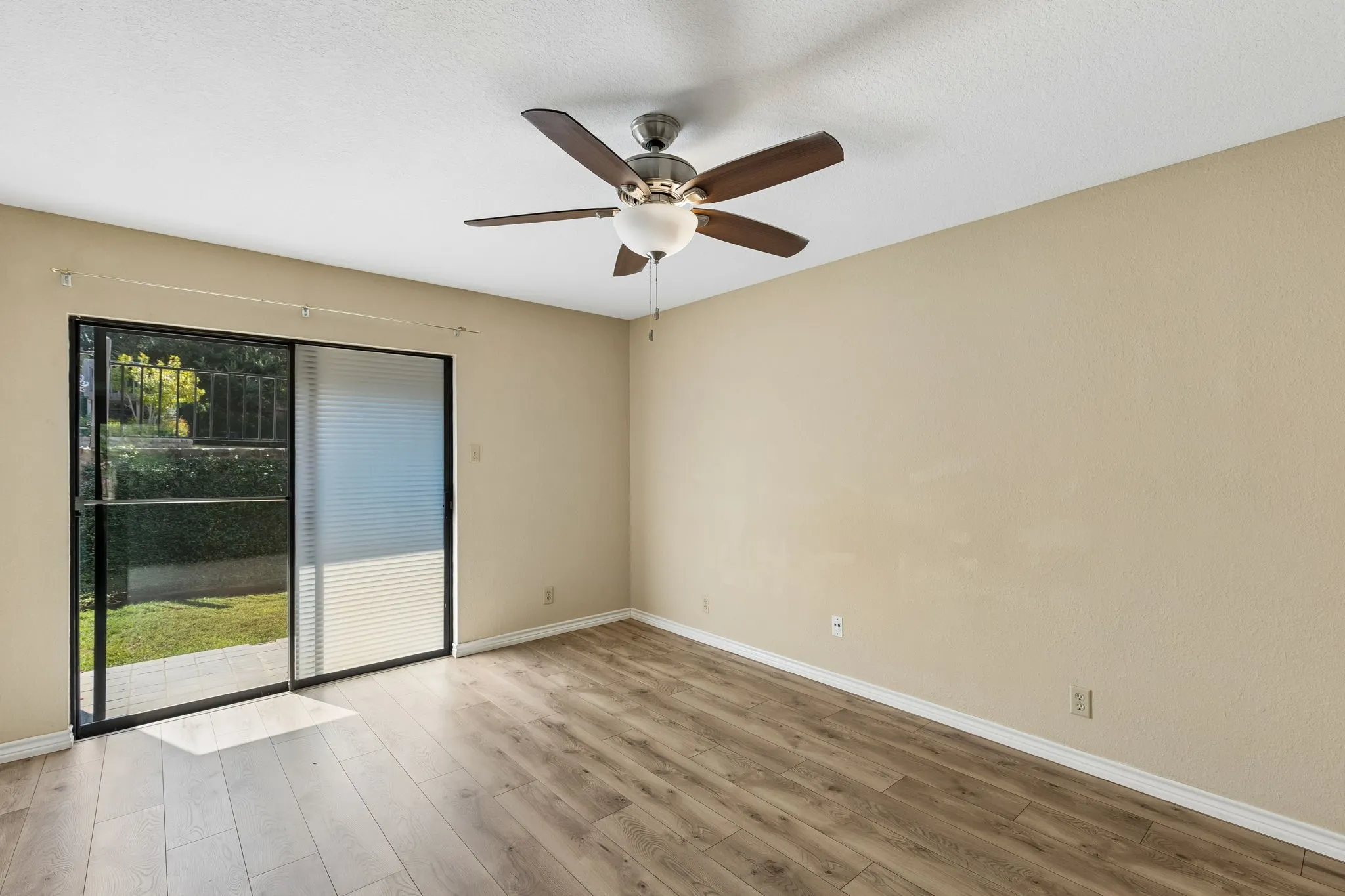 Bedroom with sliding doors and a ceiling fan